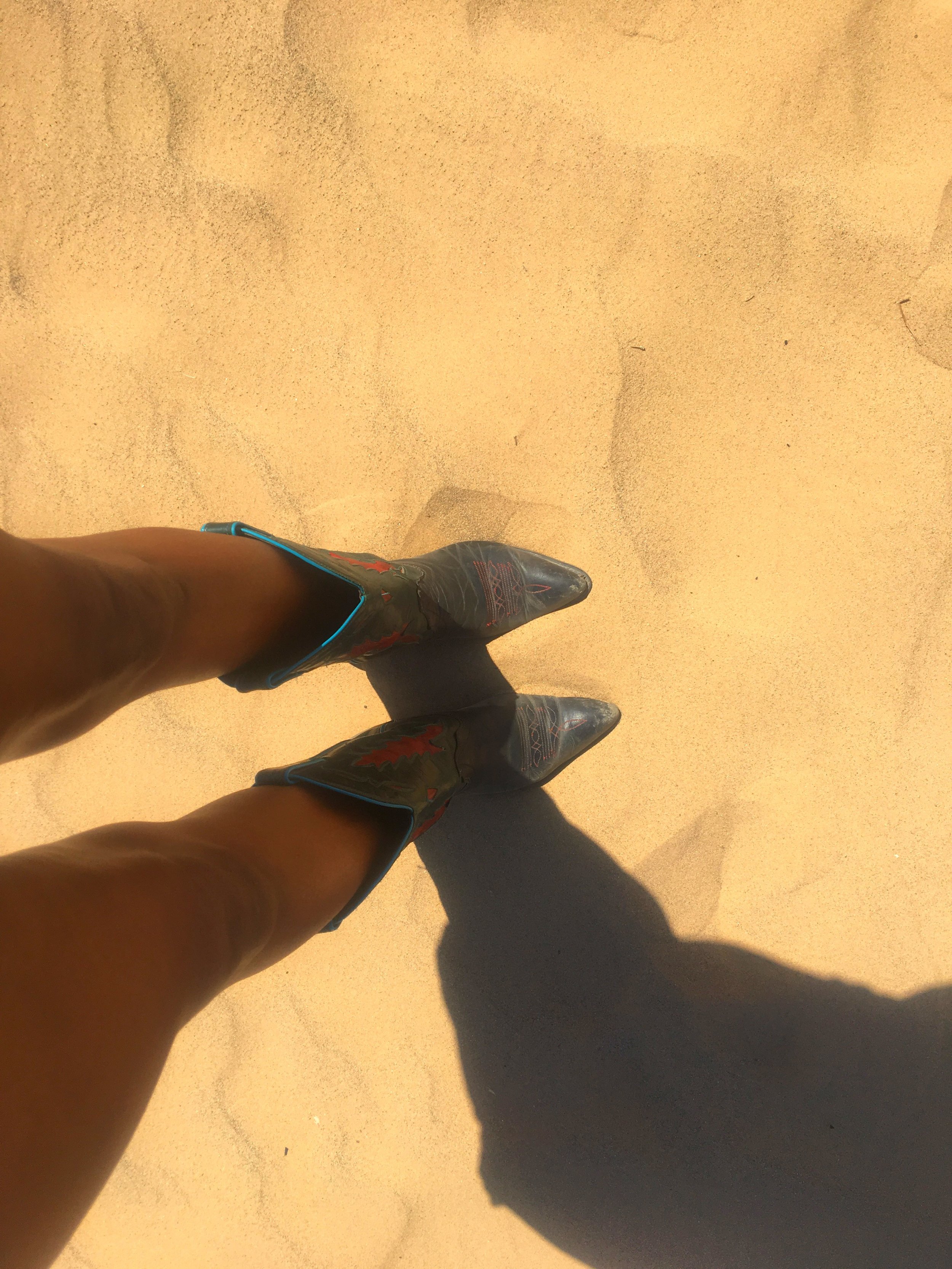 Cowboy boots standing in the sand at the Imperial Sand Dunes in California.