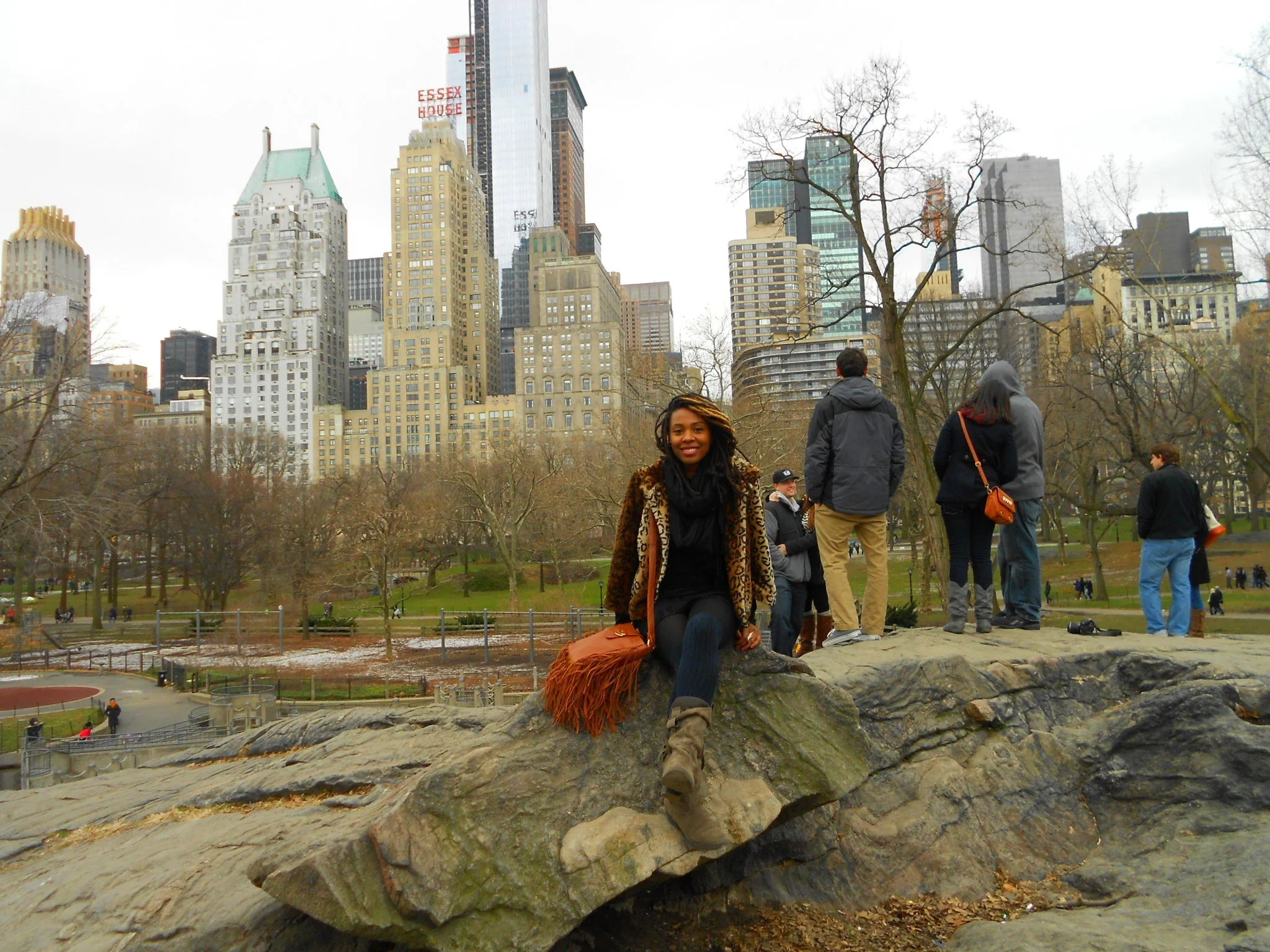 Sitting on the rocks in Central Park with the Manhattan skyline rising in the background.