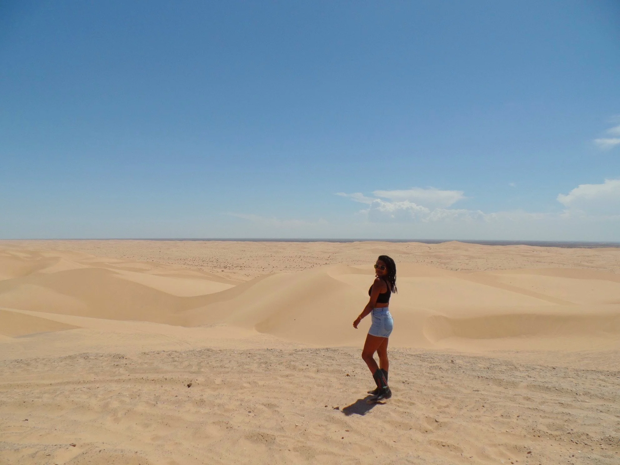 Woman walking through the Imperial Sand Dunes in Southern California.