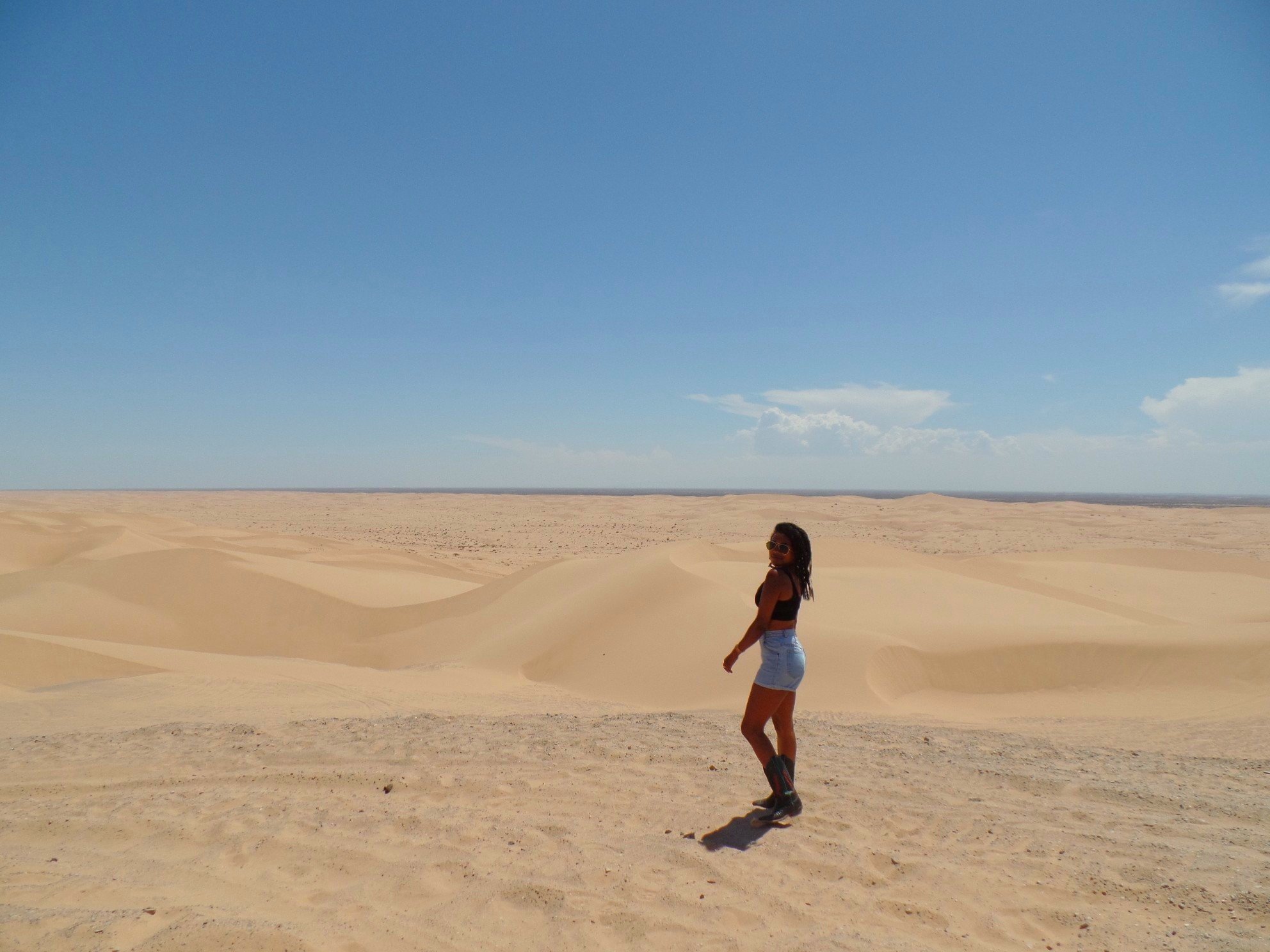 Woman walking through the Imperial Sand Dunes in Southern California.