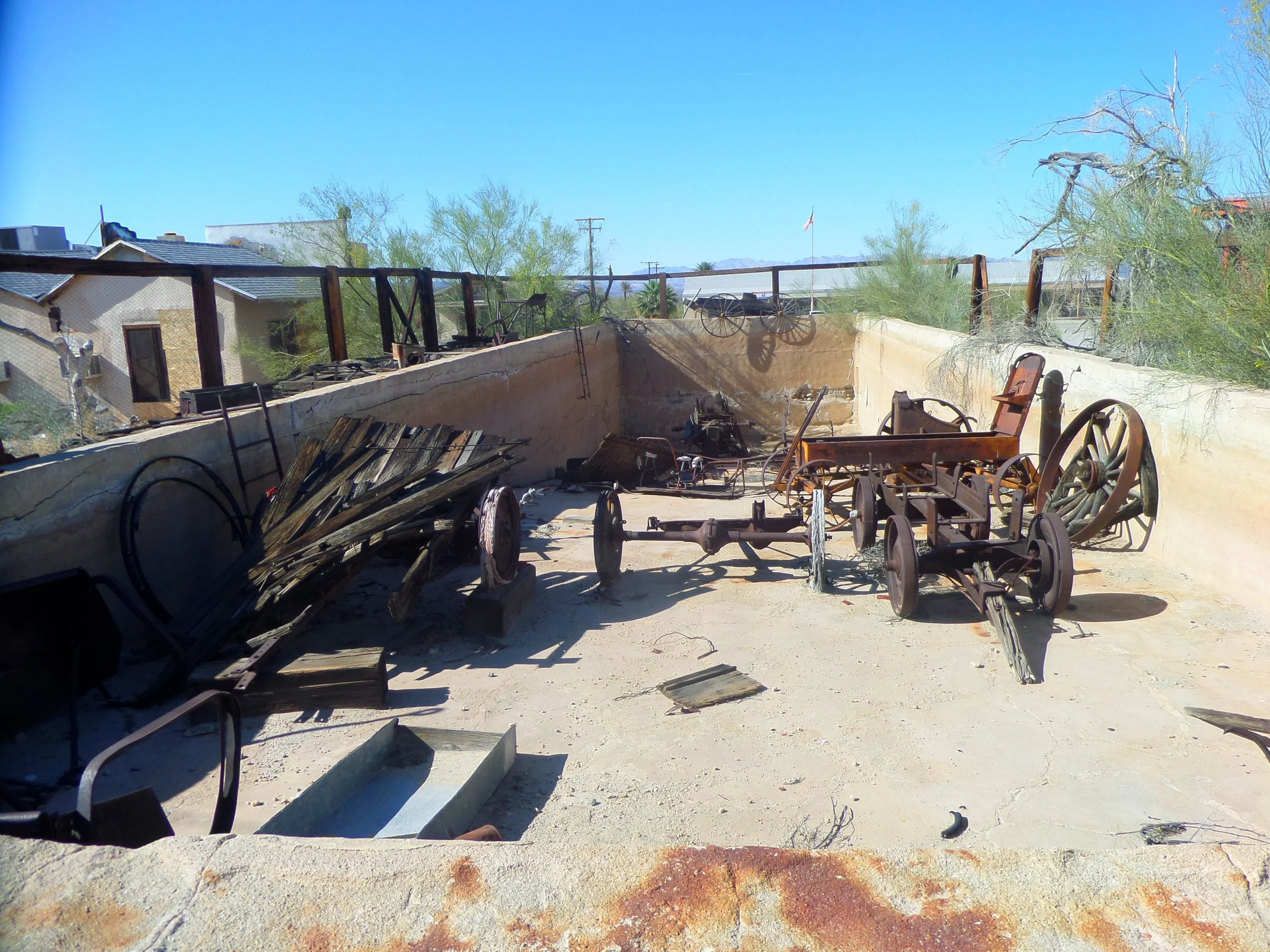 Collection of rusted wagons and agricultural equipment in Steve Ragsdale's large outdoor "plunge" pool.