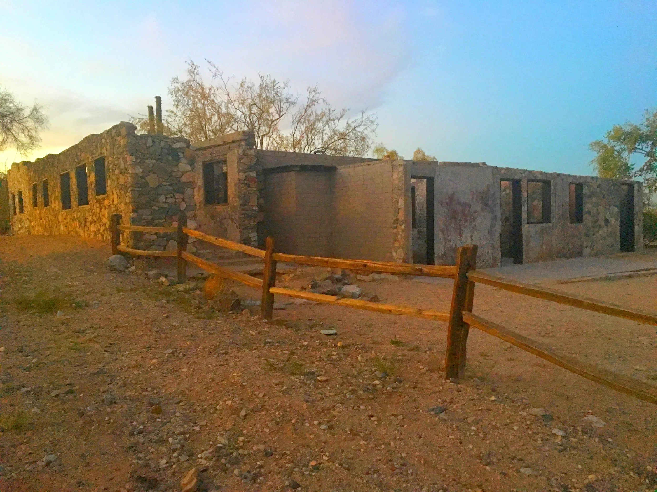 Weathered stone and concrete walls of the historic Scorpion Gulch ruins behind a wooden fence in Phoenix, Arizona, in 2016.