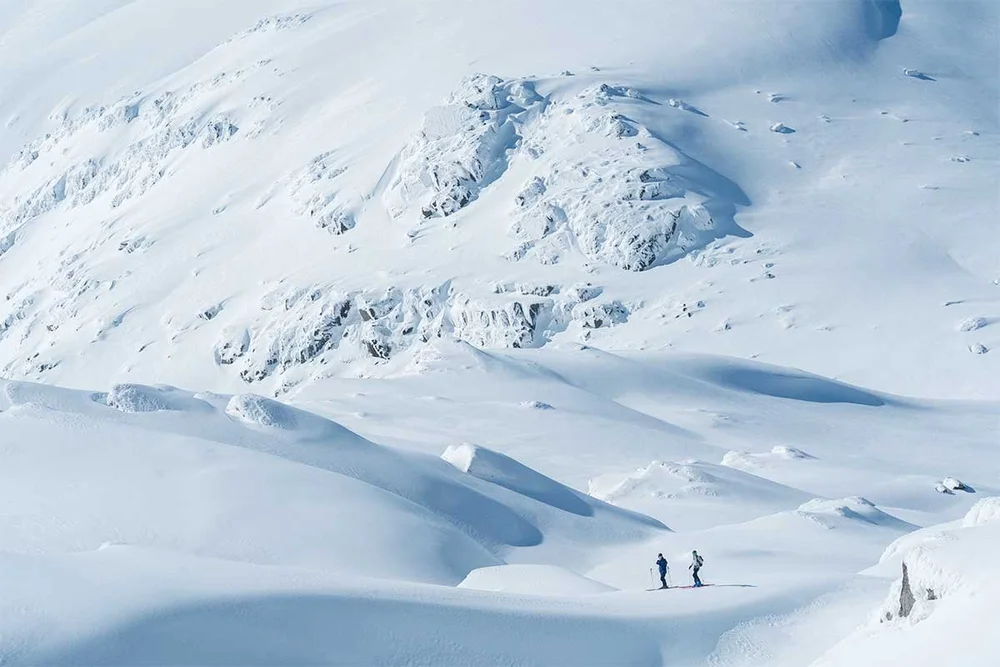 Two skiers on a steep Kosciuszko face