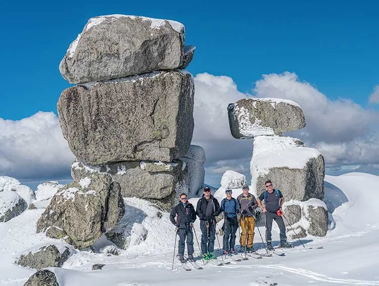 Backcountry ski group among granite tors