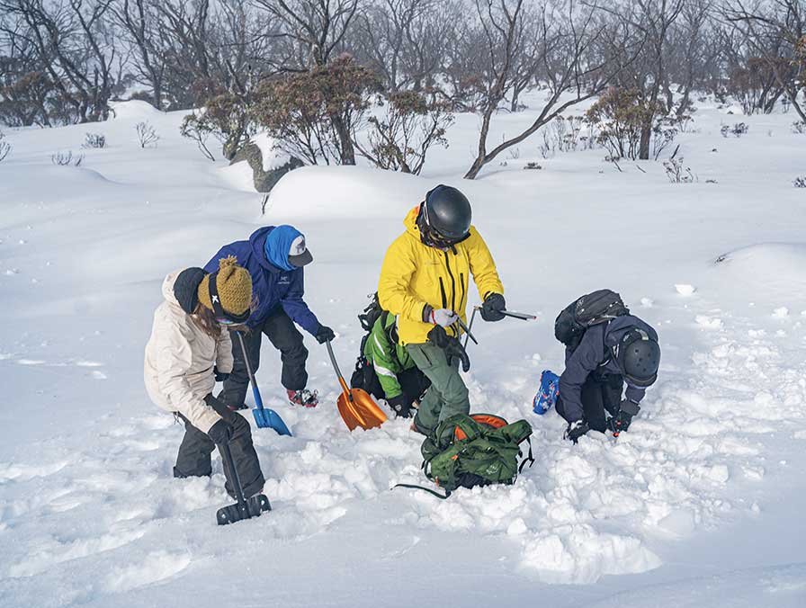 Group resting on the snow during a Main Range tour
