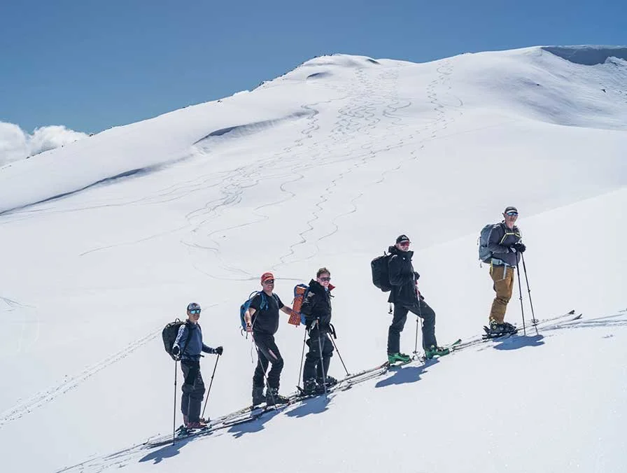 A group skinning up a snowy Main Range slope