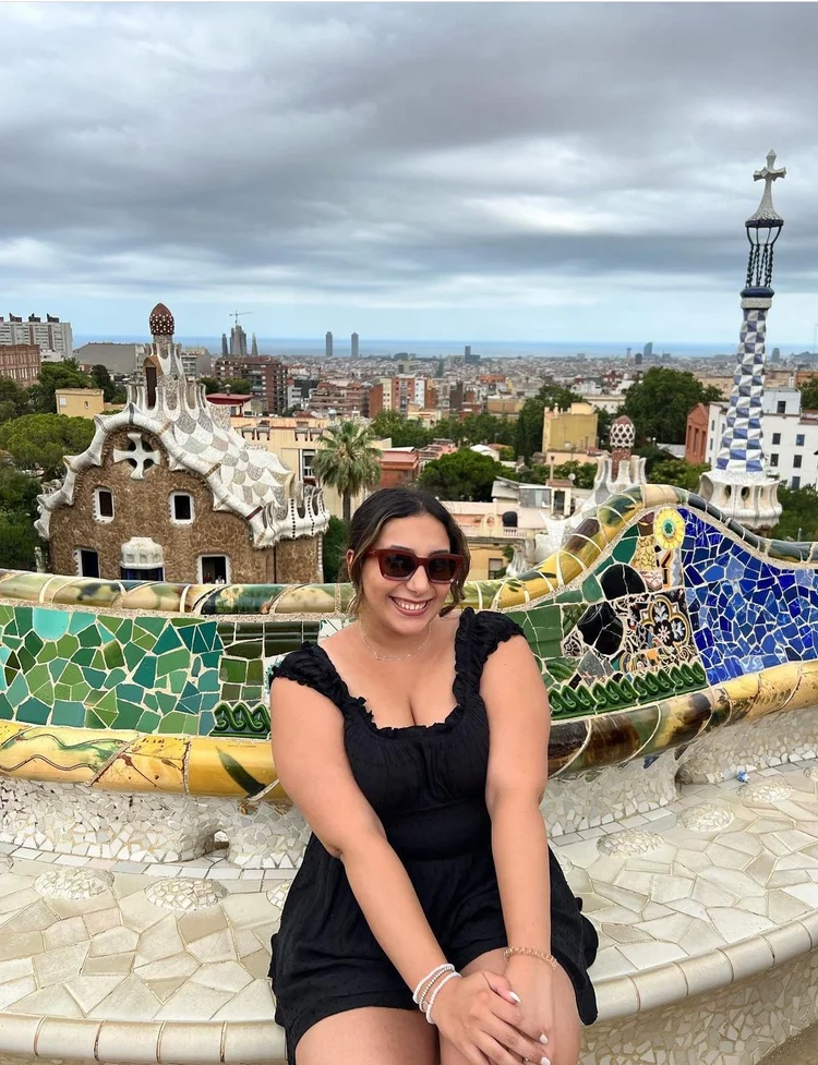 Avita on a mosaic bench above a city