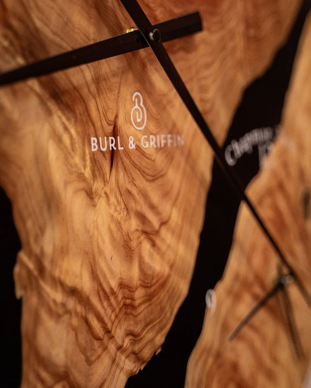 Close-up of the Burl & Griffin logo etched into the Cypress Pine and black resin.