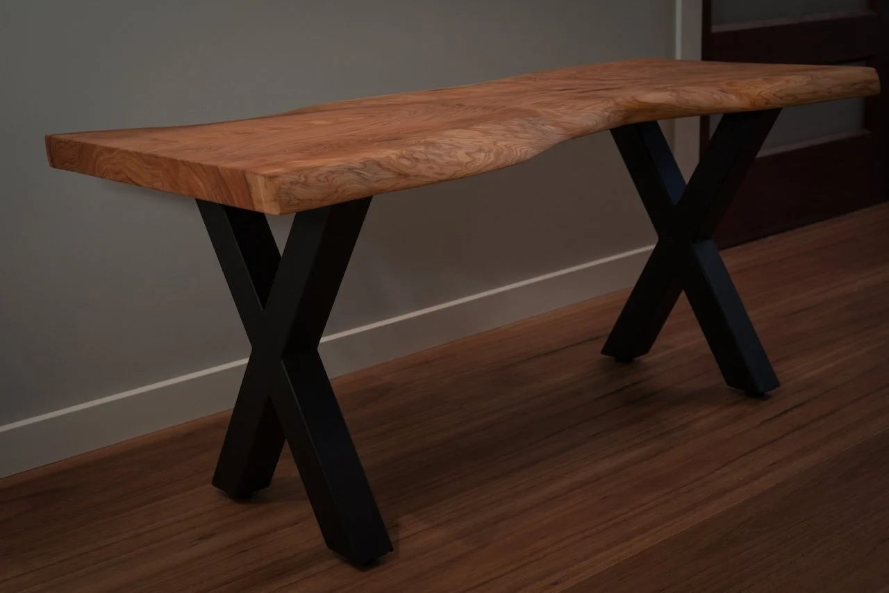 A full profile view of the timber bench, displaying the balance between the rustic natural top and the modern industrial legs.