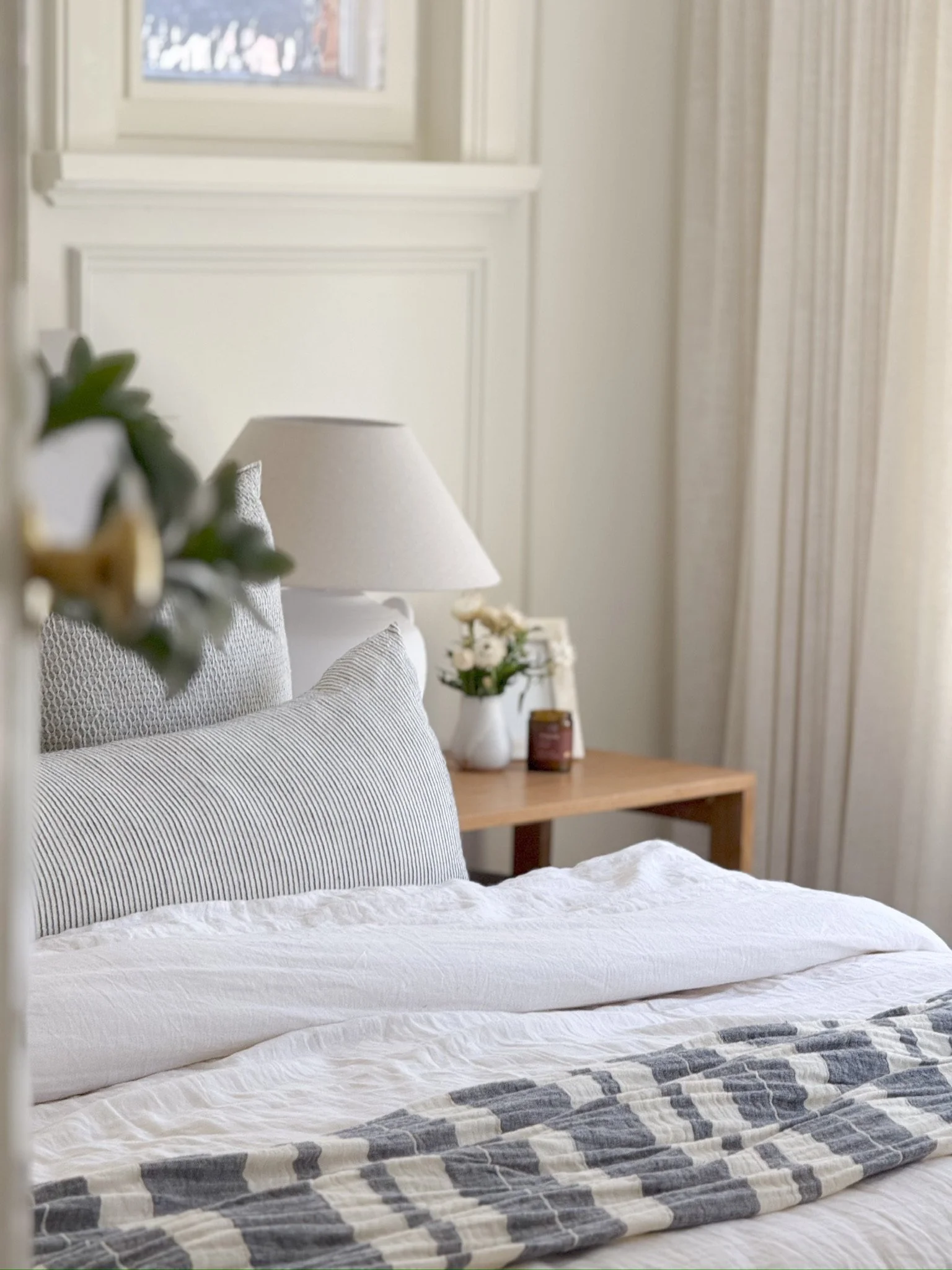 Styled bedroom with layered linen bedding and a lamp on the bedside table, interior styling by Adelaide interior designer The Clarke Collection