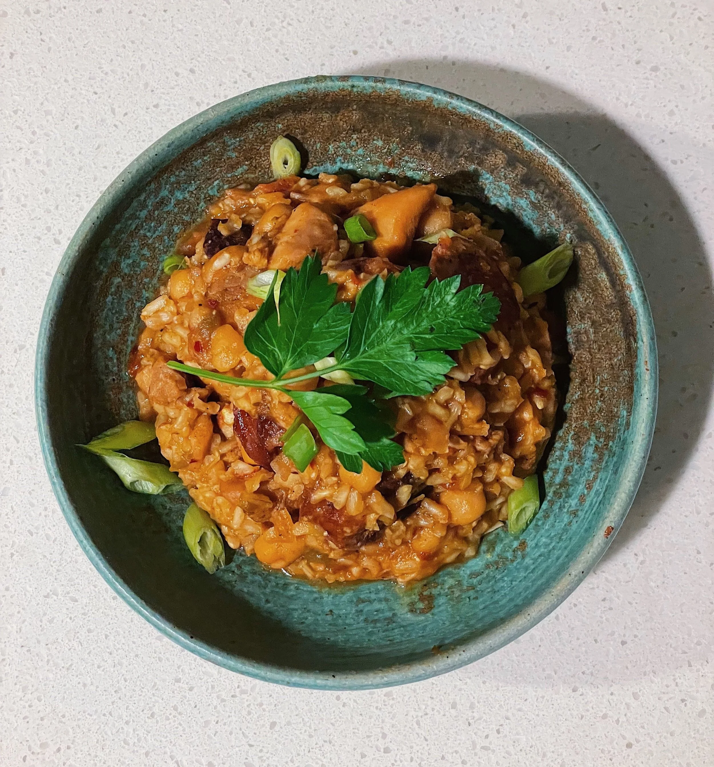 Steamy jambalaya with chickpeas served in a large bowl, garnished with parsley.