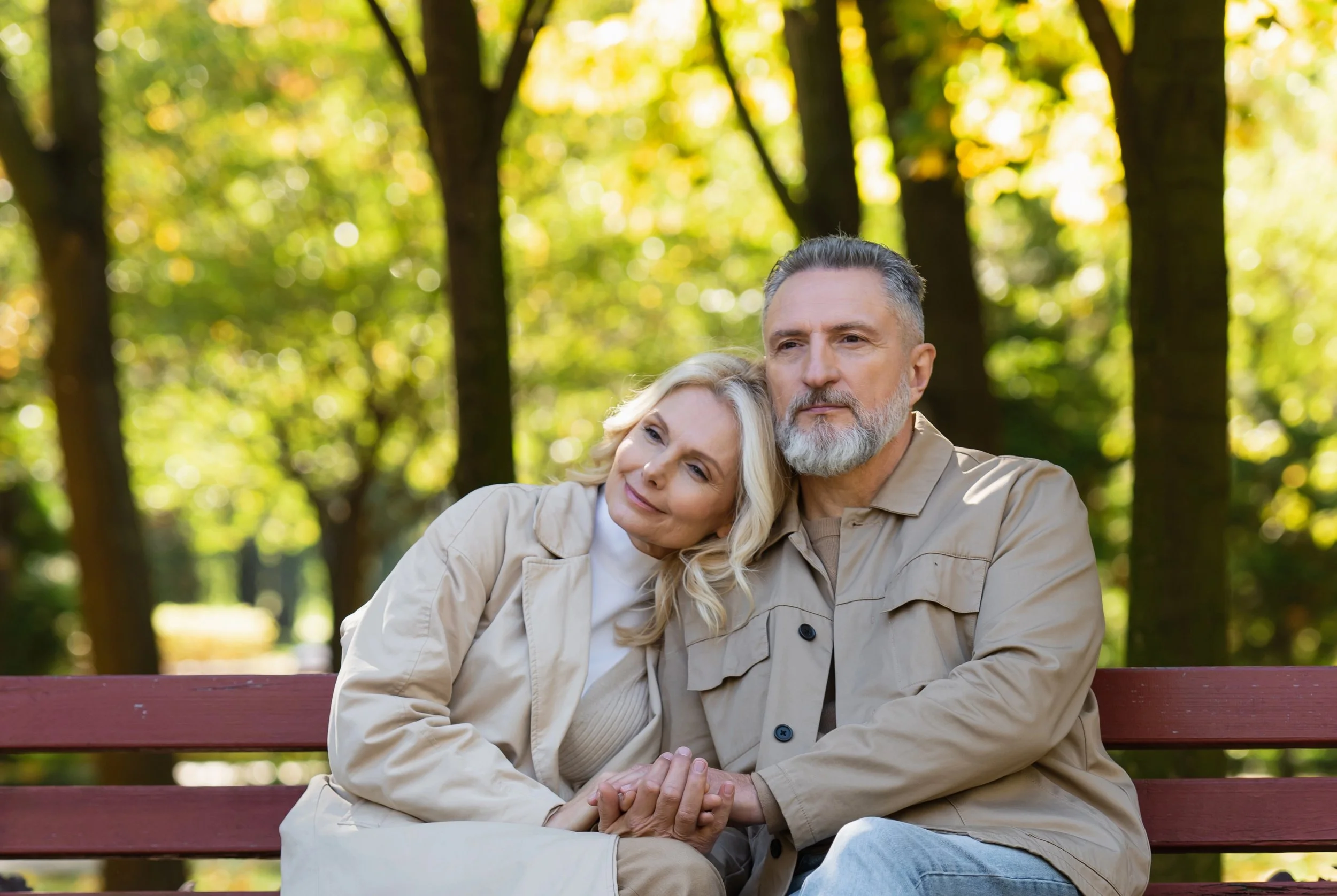 Christian couple in late career enjoying time together on a park bench.