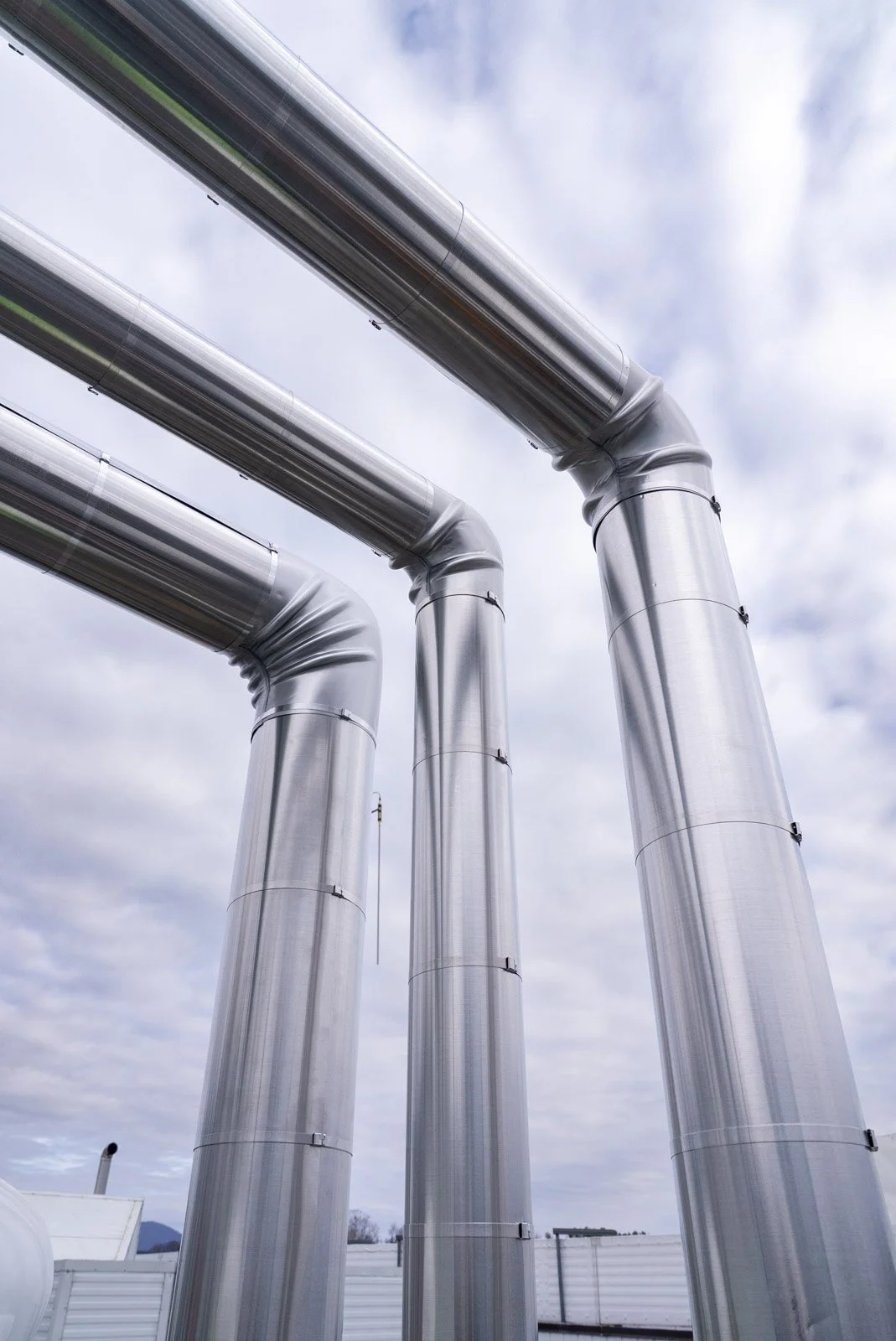 Insulated rooftop piping against the sky at the poultry processing facility