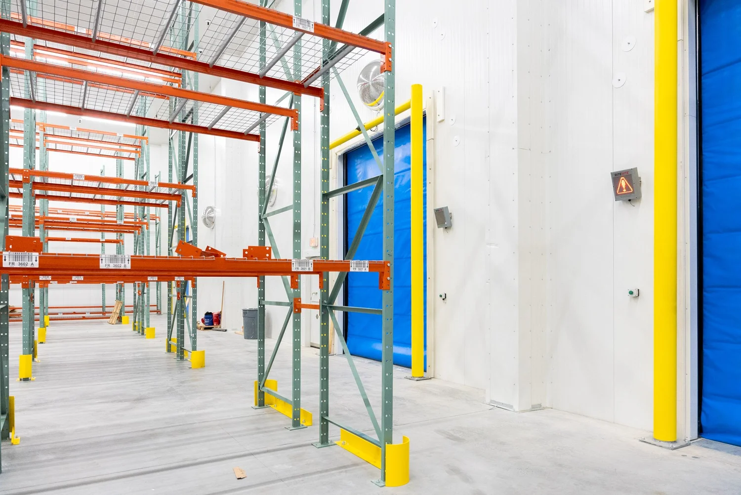 Finished cold storage room with pallet racking and a blue insulated high-speed door