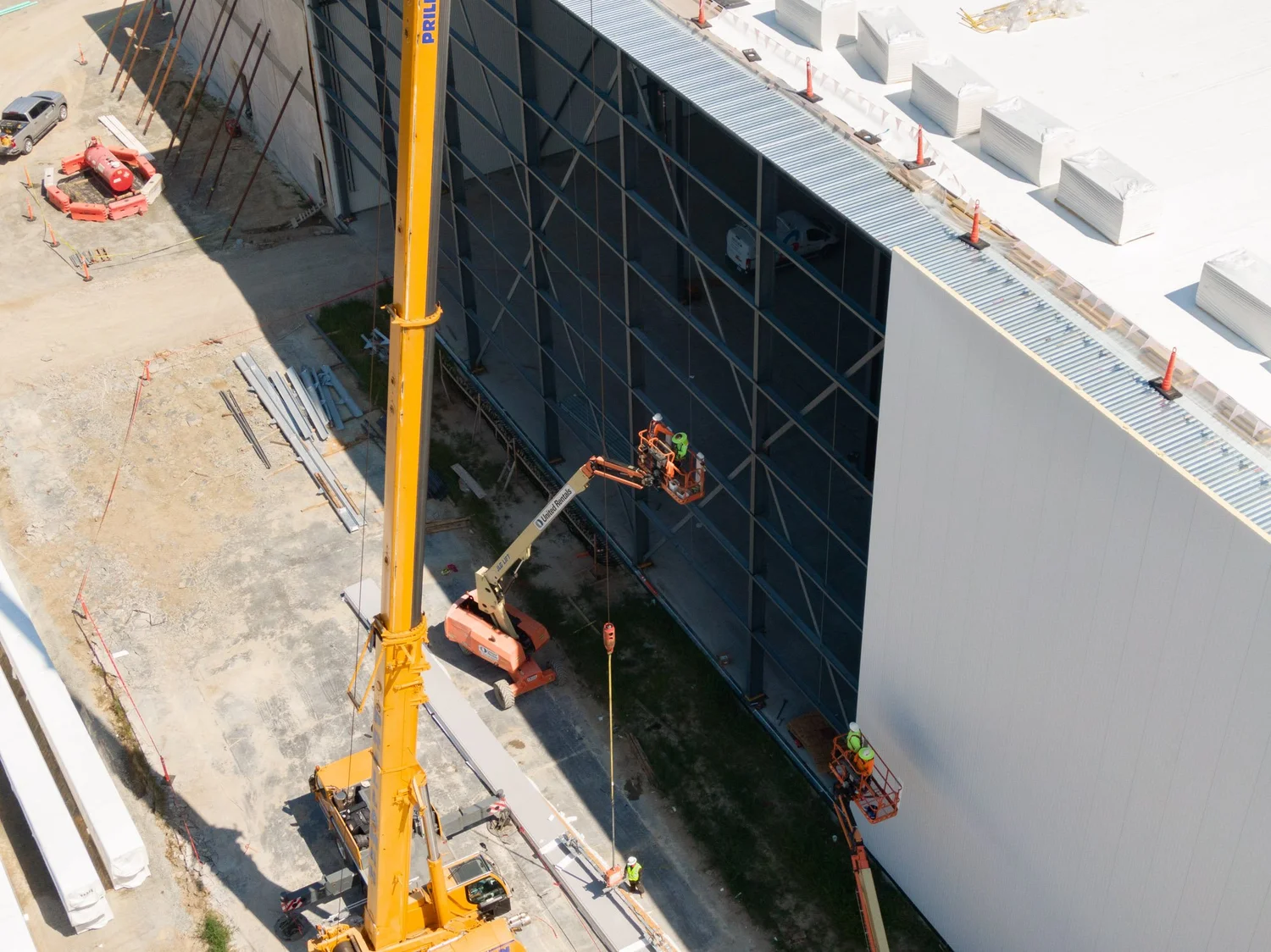 Crane and lift installing insulated metal panels on the FreezePak building exterior