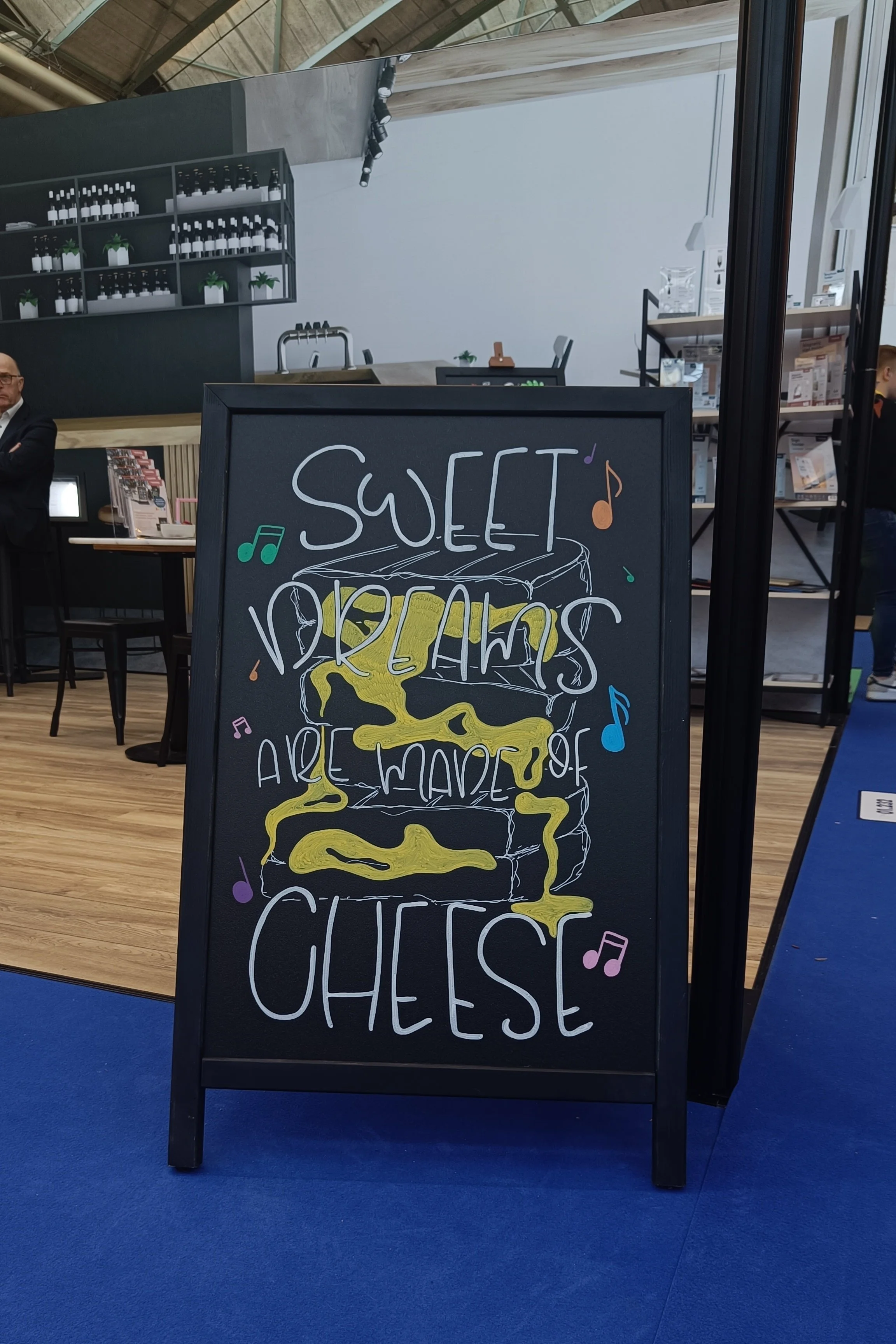 Krijtbord met kleurrijke illustraties en de tekst 'Sweet dreams are made of cheese'