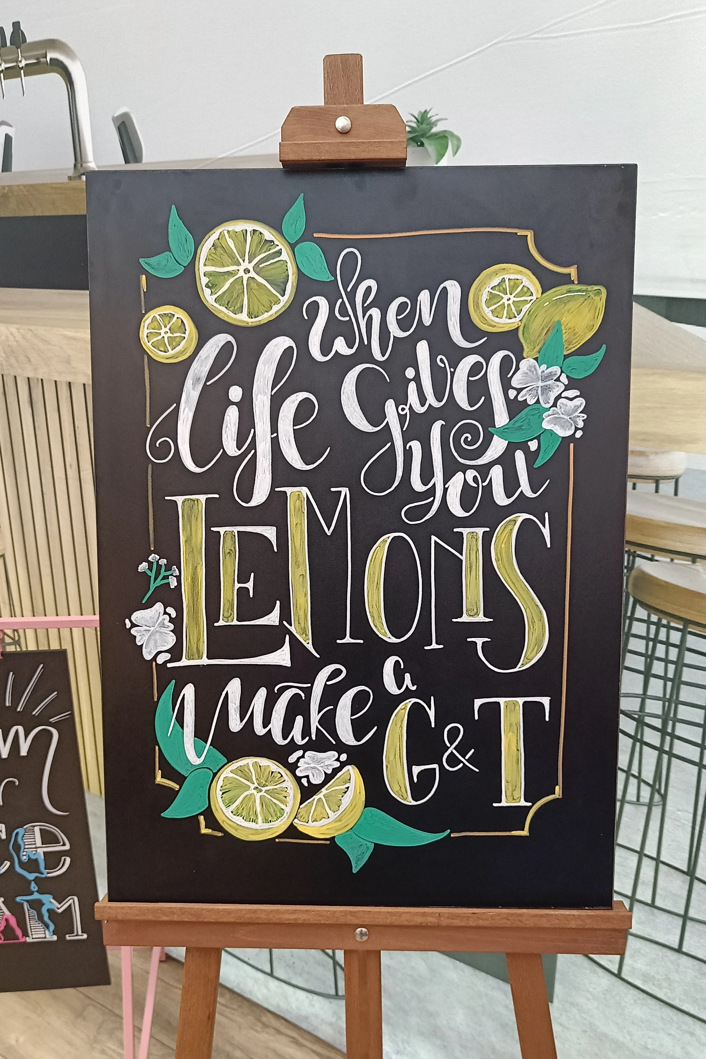 Krijtbord met kleurrijke illustraties en de tekst 'When life gives you lemons, make G&T'
