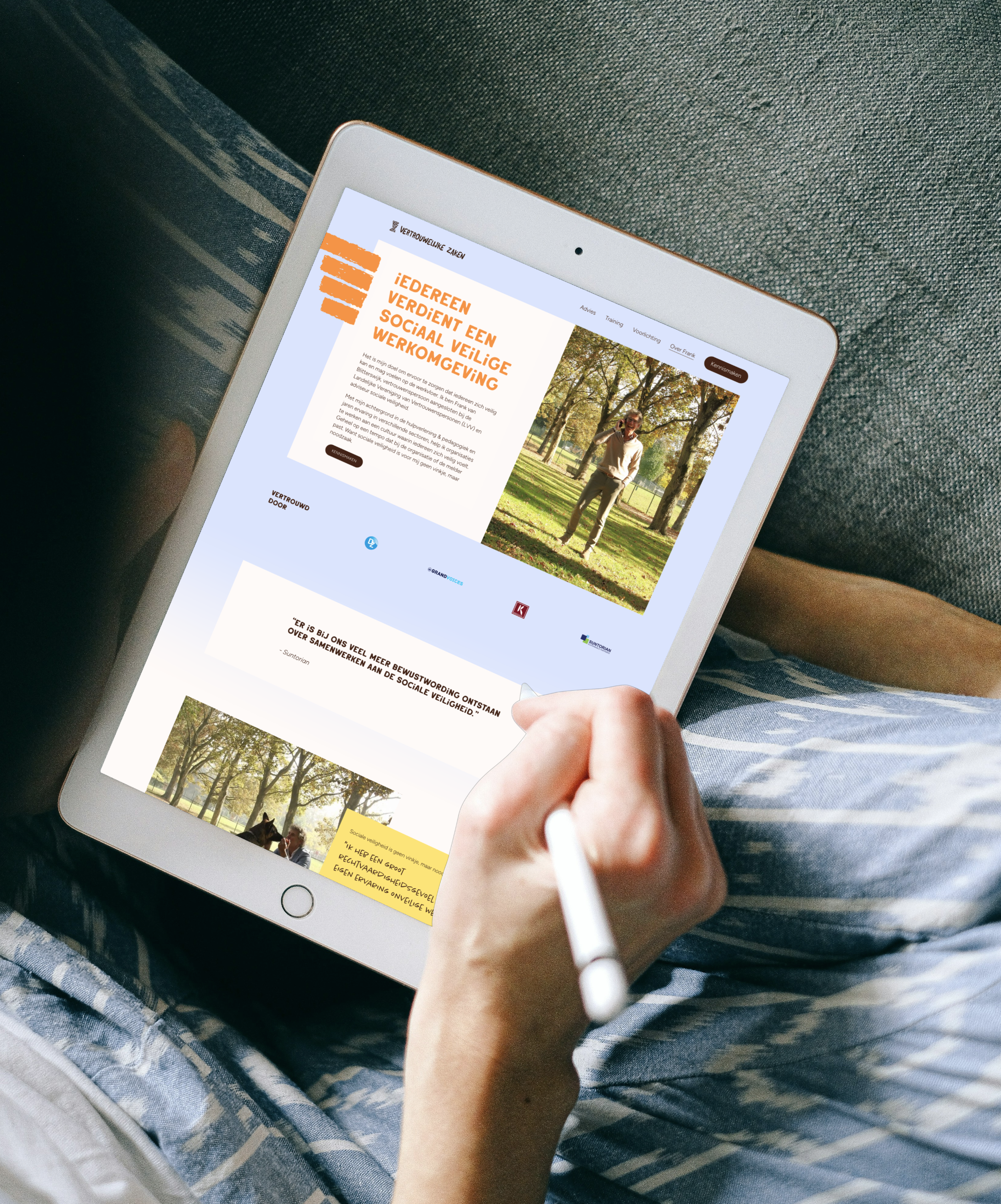 Persoon die op een tablet schrijft terwijl ze op een bank zit, met een app over sociale veiligheid en een foto van een man in een park.