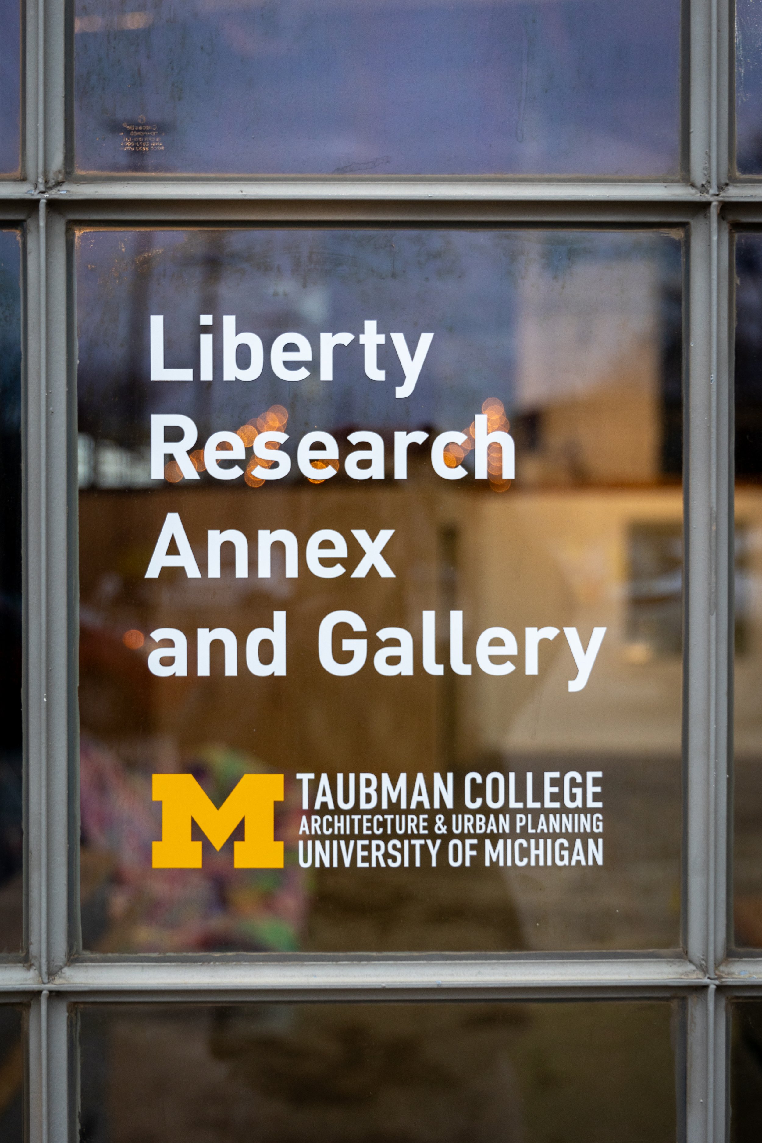 A glass pane from a window with the words "Liberty Research Annex and Gallery" written in white letters