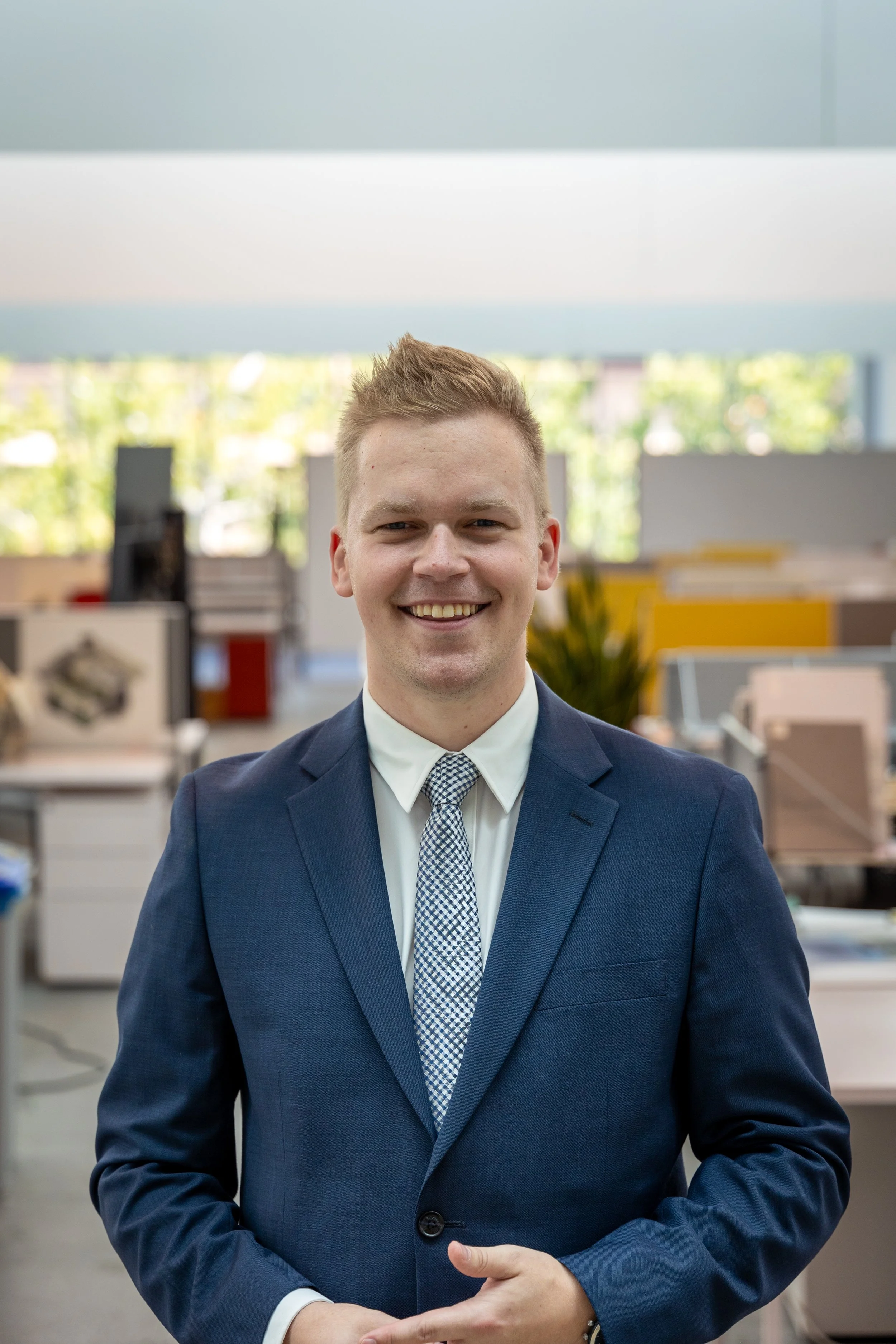 A headshot of a man in a suit with a kind smile