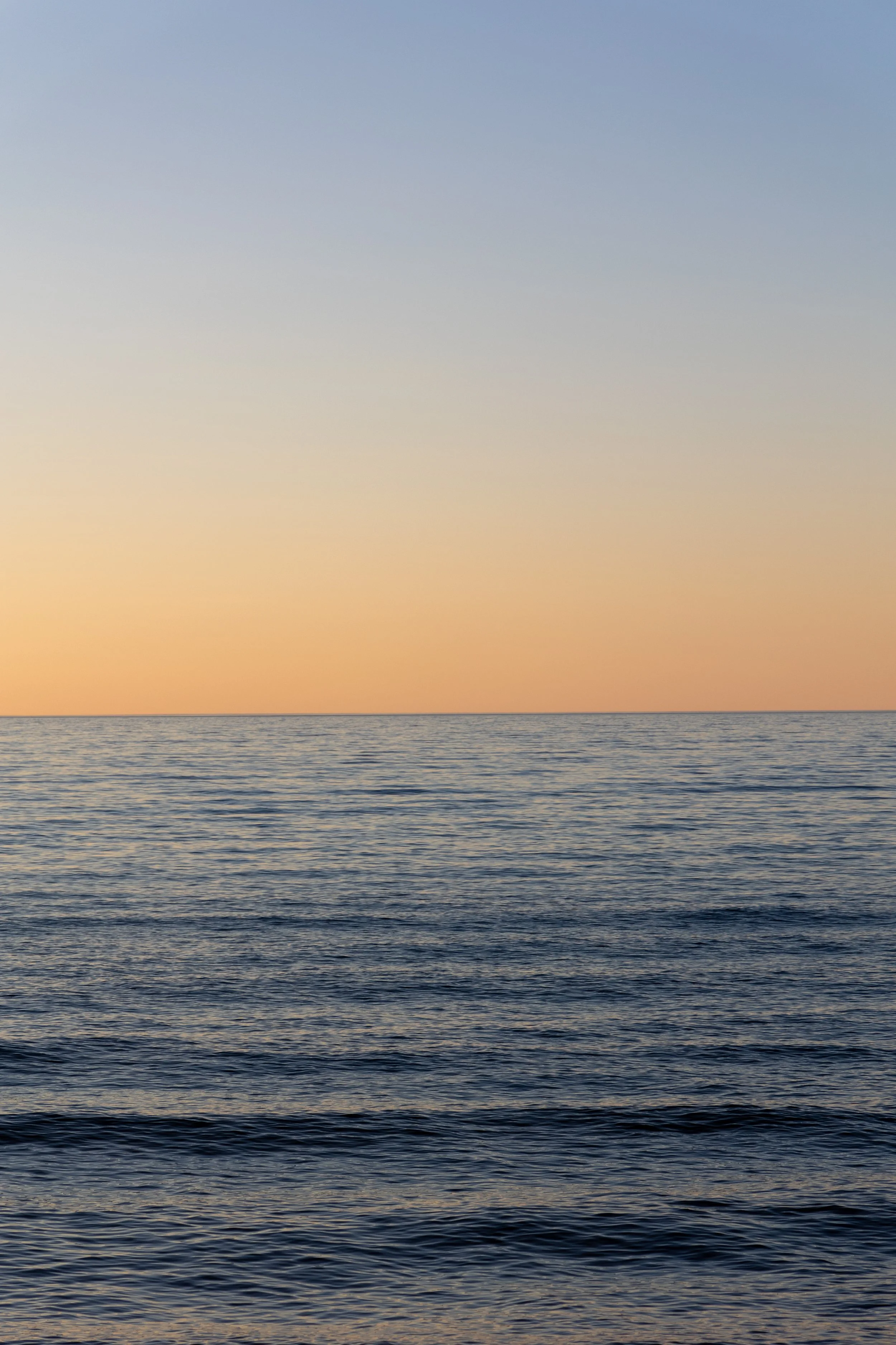 A gradient sunset over a large body of water