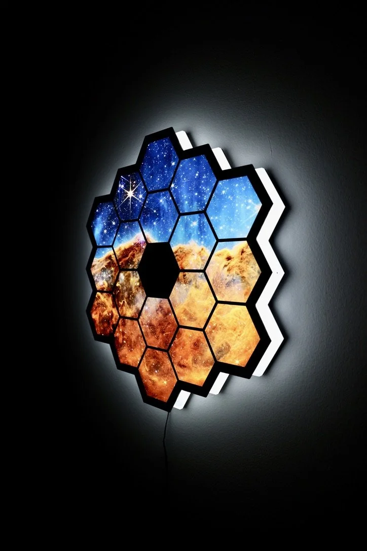 An illuminated LED sign in the shape of the James Webb Telescope featuring one of the photos the telescope took
