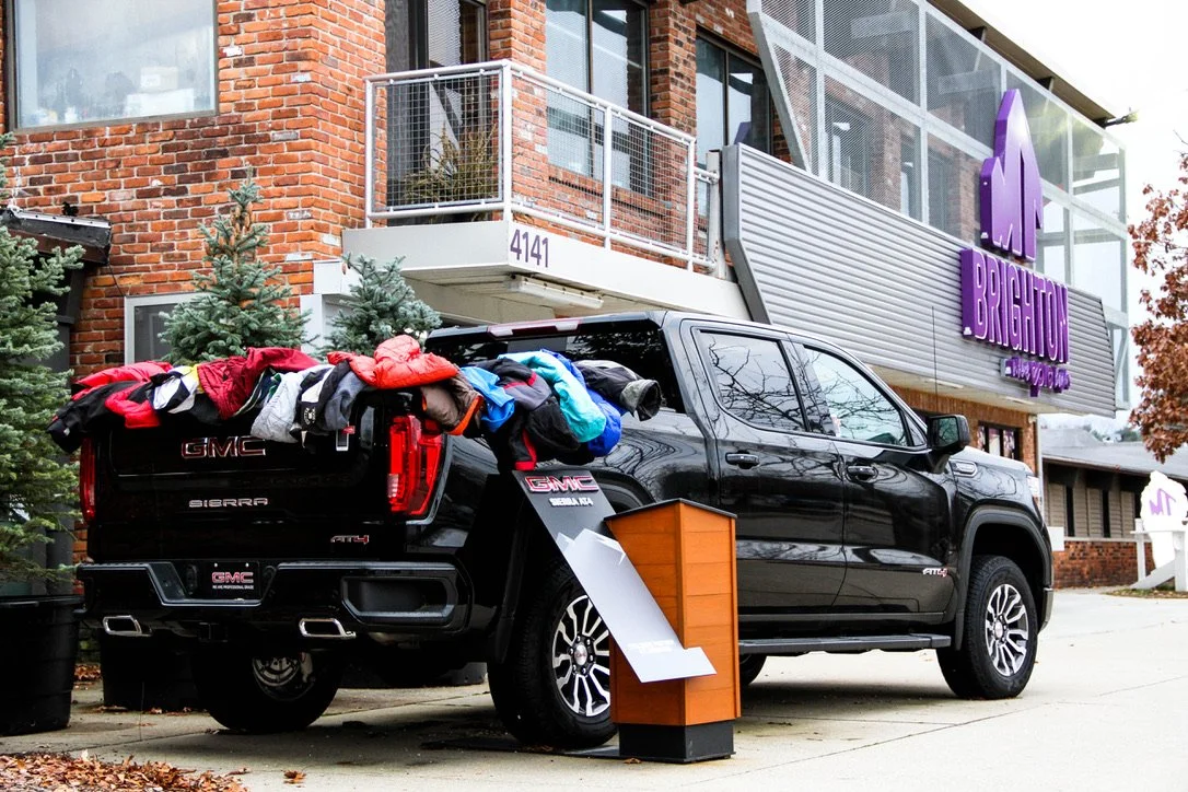 A GMC pickup truck with the truck bed loaded with clothing