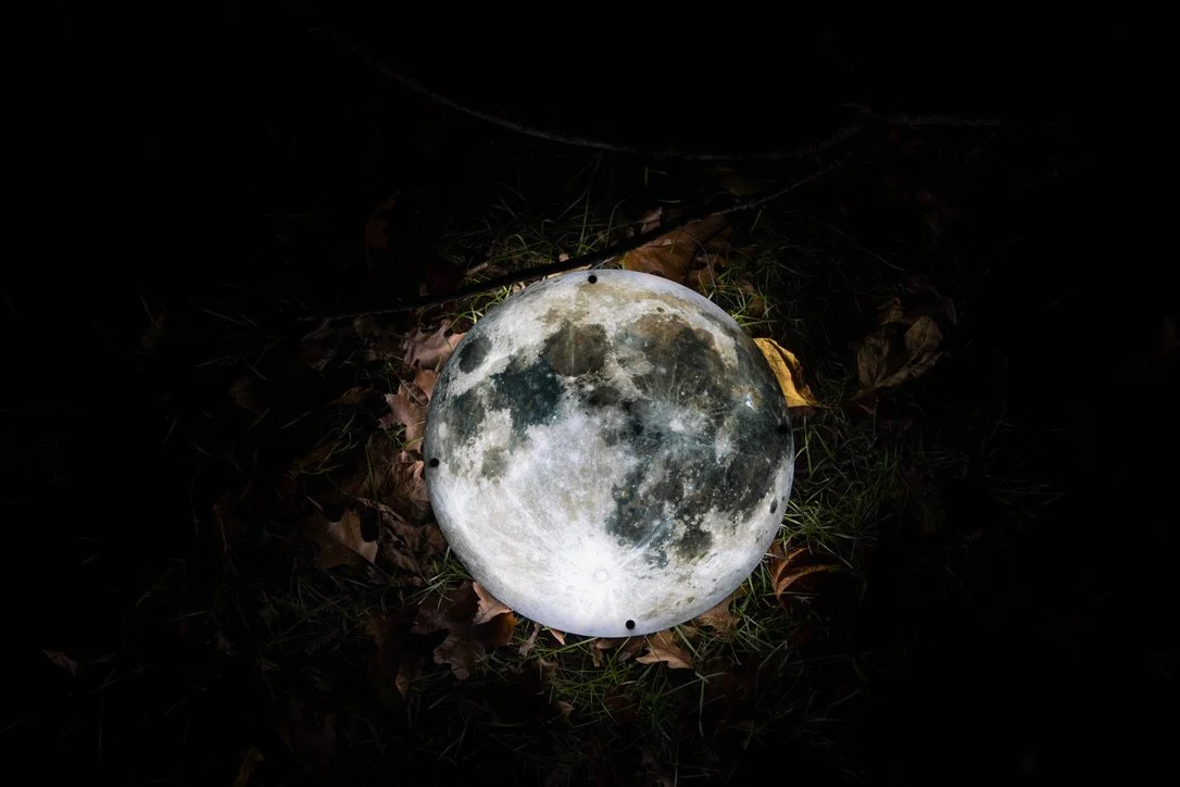An illuminated moon LED sign in the dark