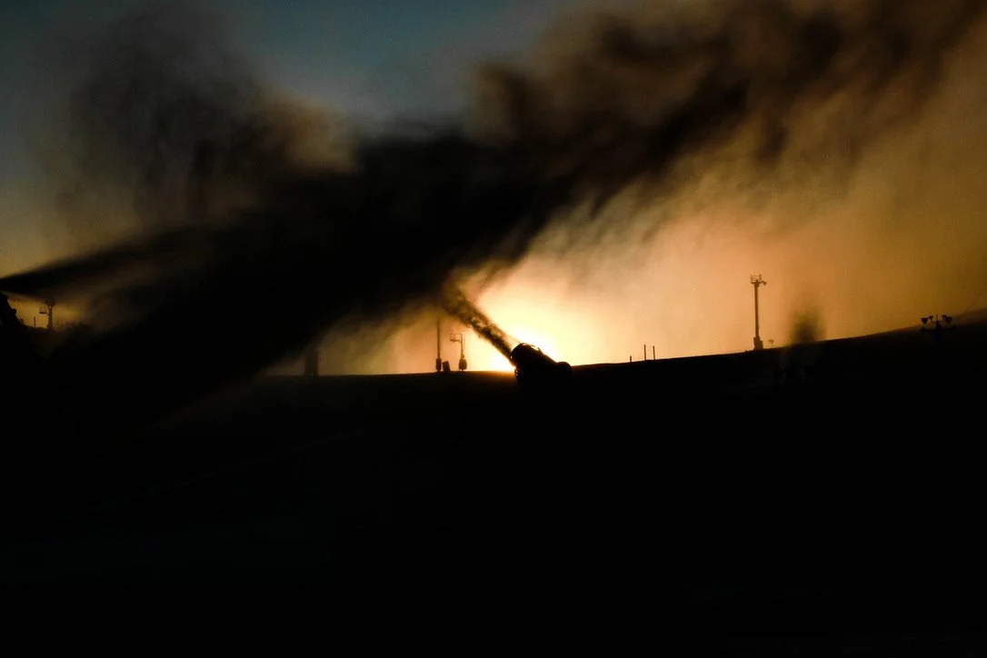 An early morning sunrise with snow machines making snow in the foreground
