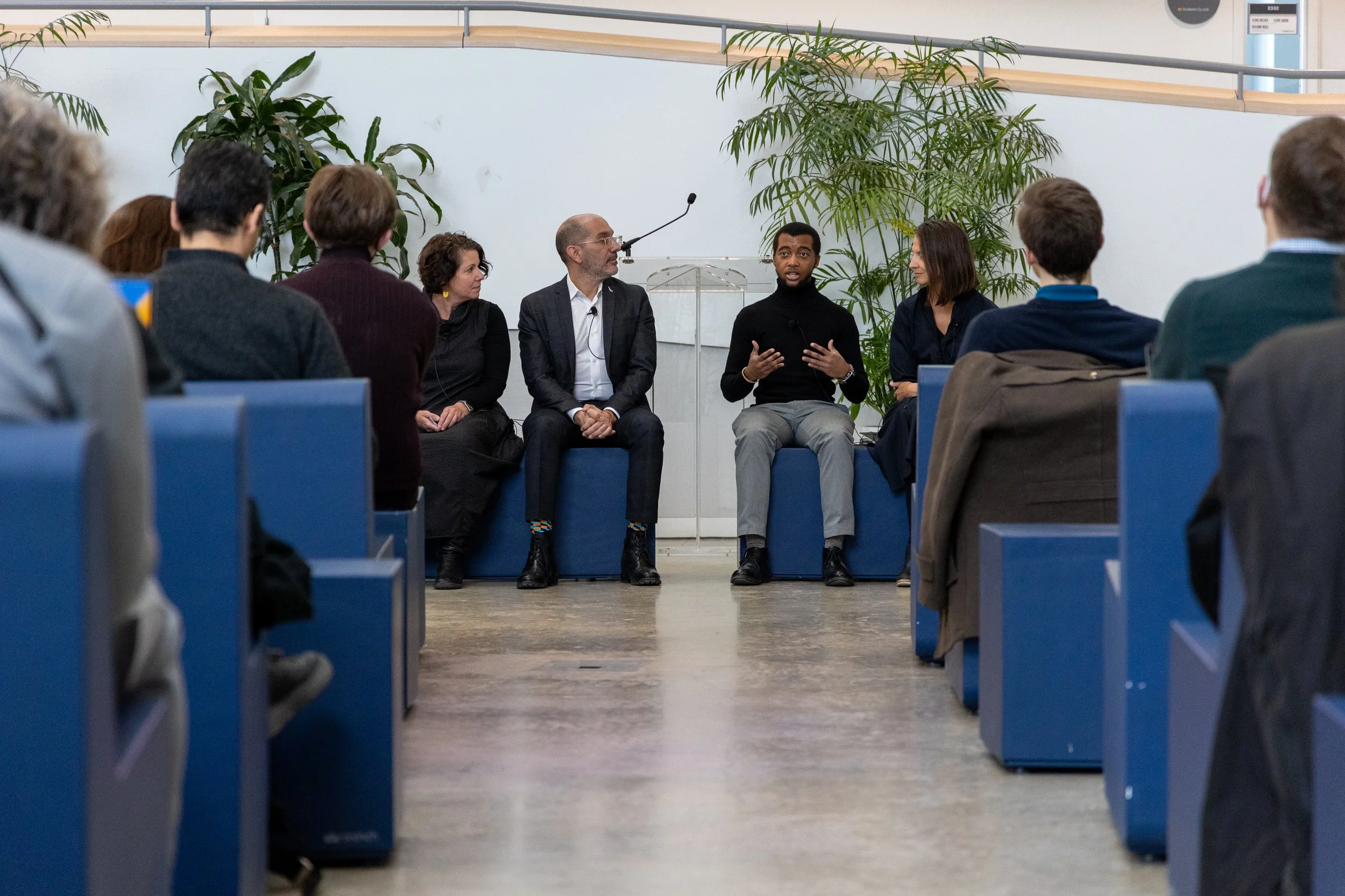 A panel of speakers looking at each other during a lecture