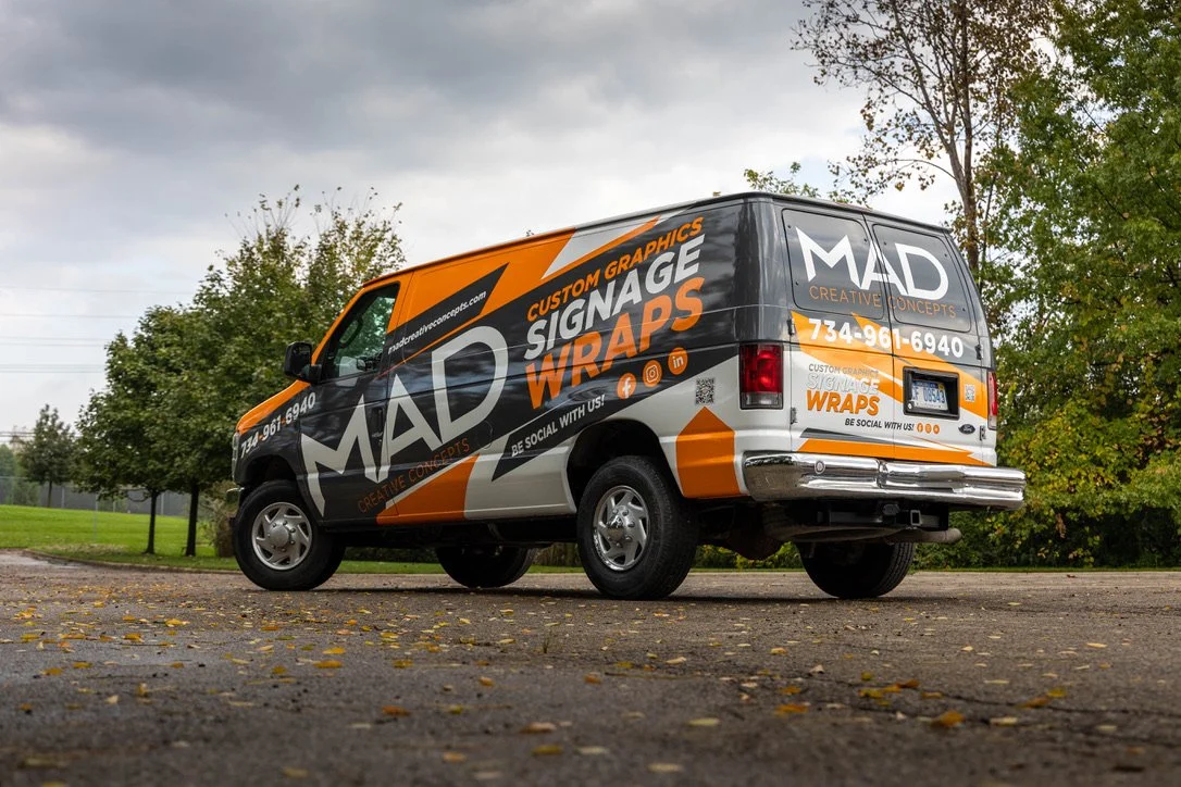 A parked van has a vinyl wrap covering the entire vehicle