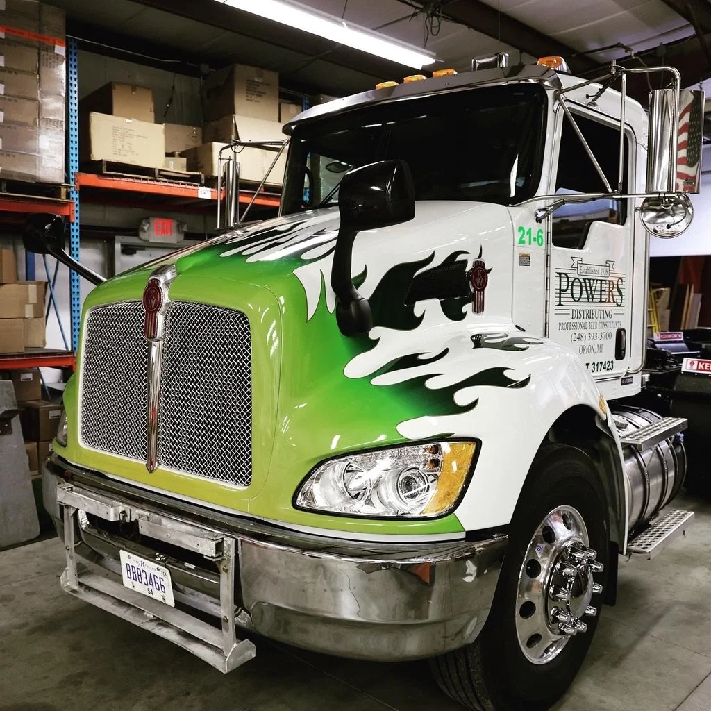 A semi truck with vinyl graphic of green flames