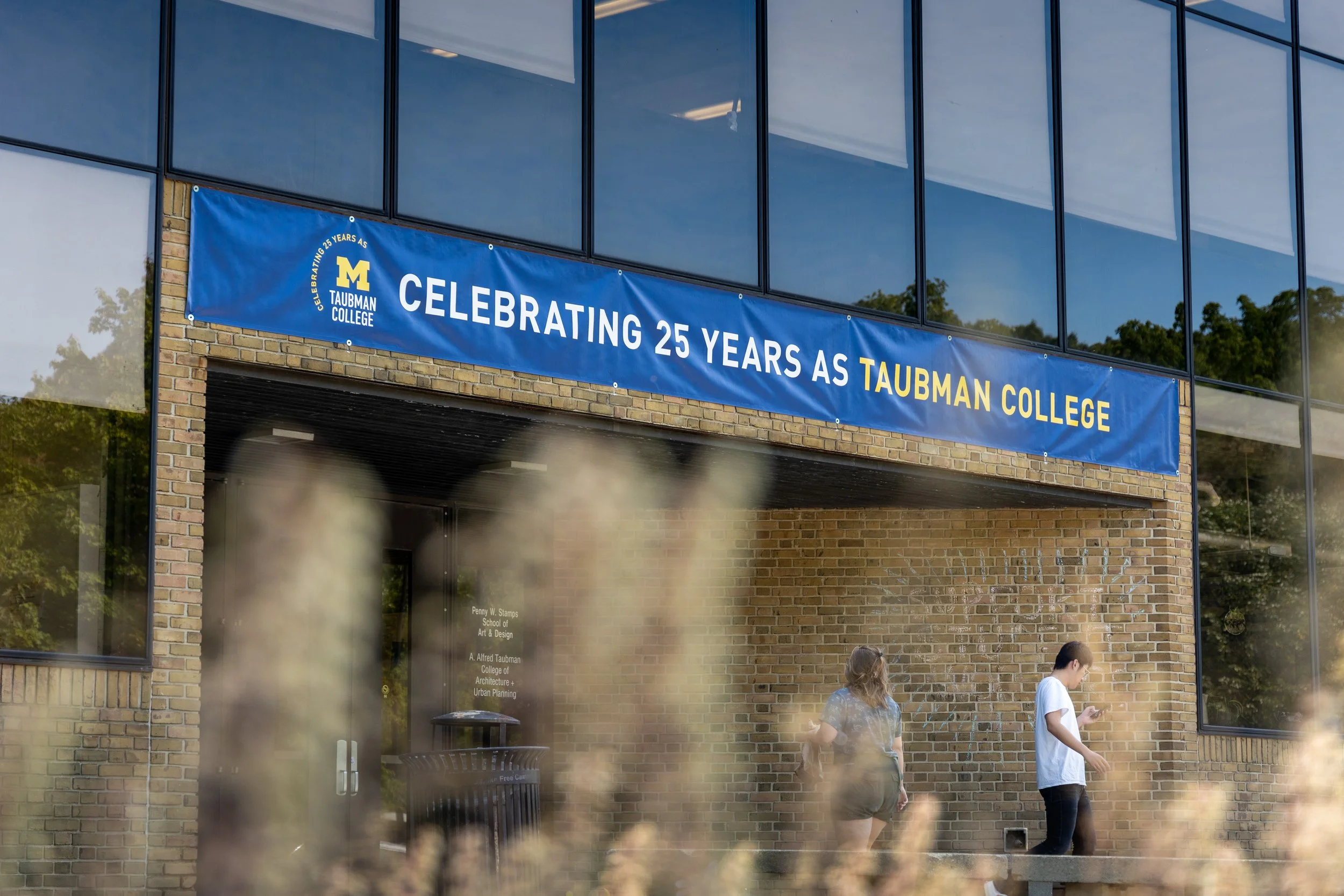 The entrance of a building with a sign that reads "Celebrating 25 Years as Taubman College"