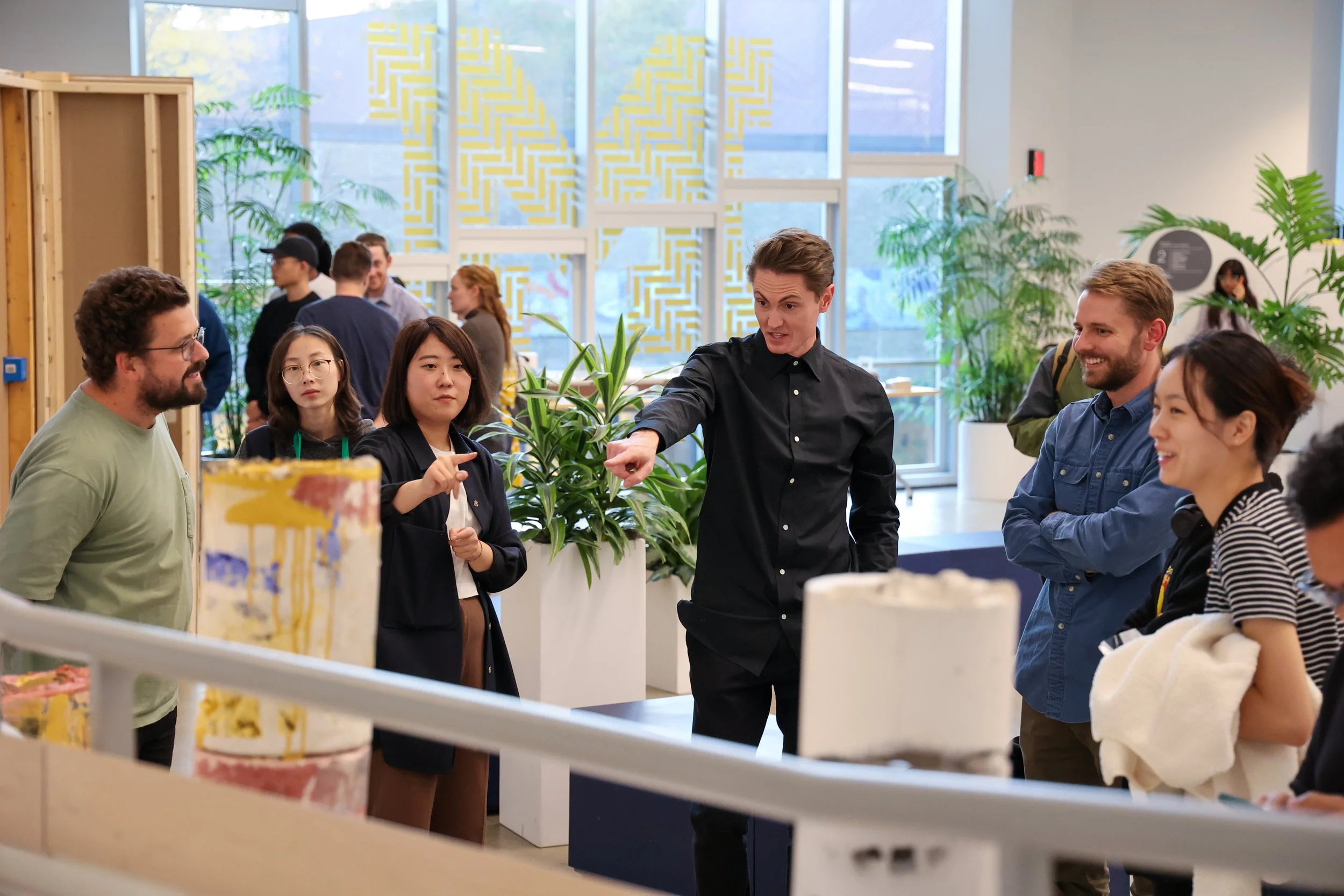 A group of students discuss architecture work in an atrium