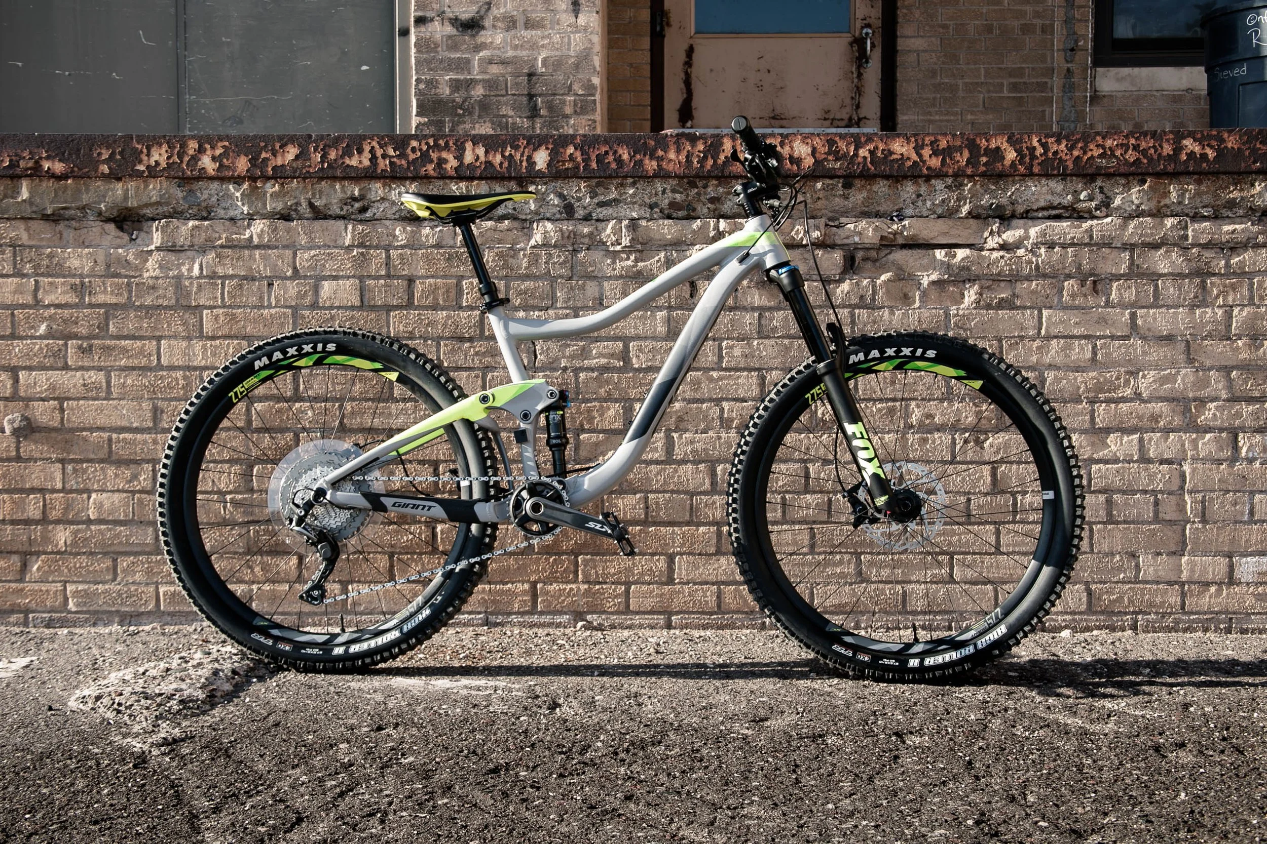 A Giant brand mountain bike in front of a industrial brick wall