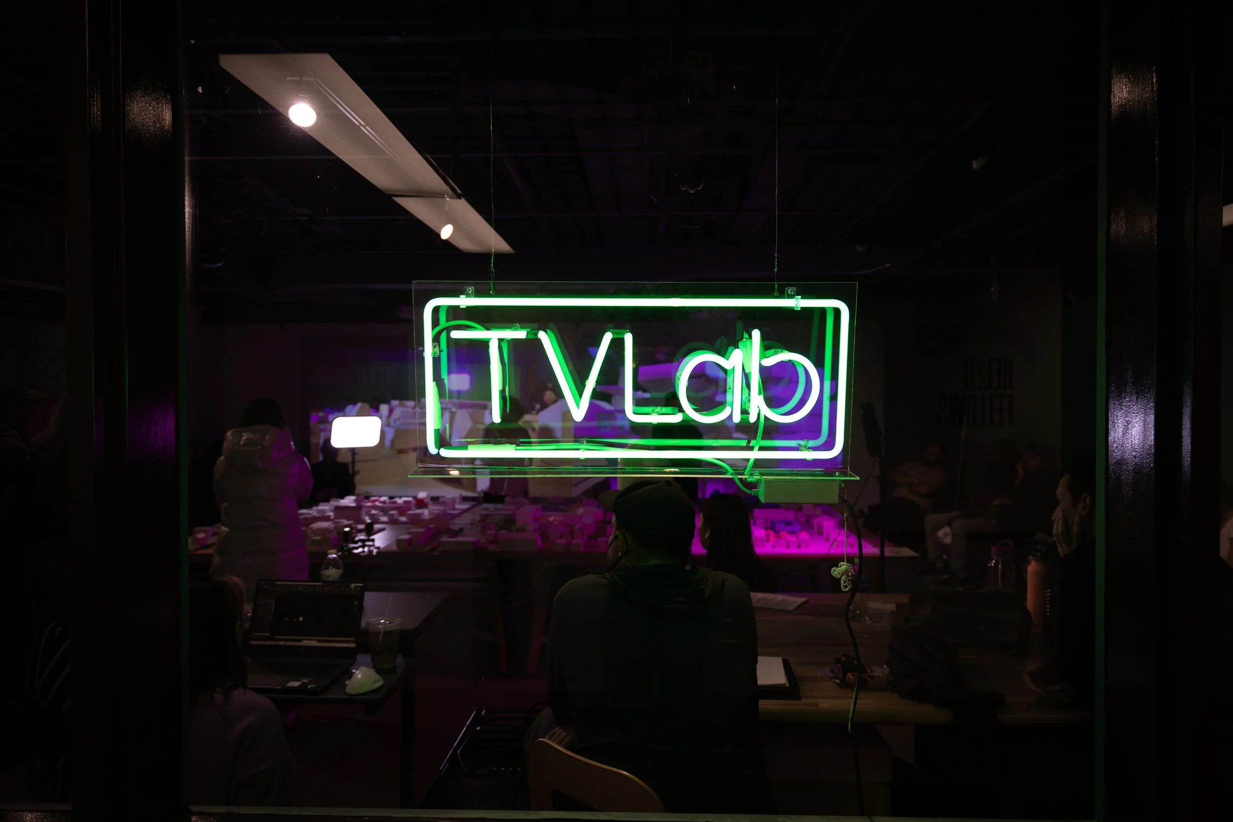 A neon sign with the words "TVLab" written in green