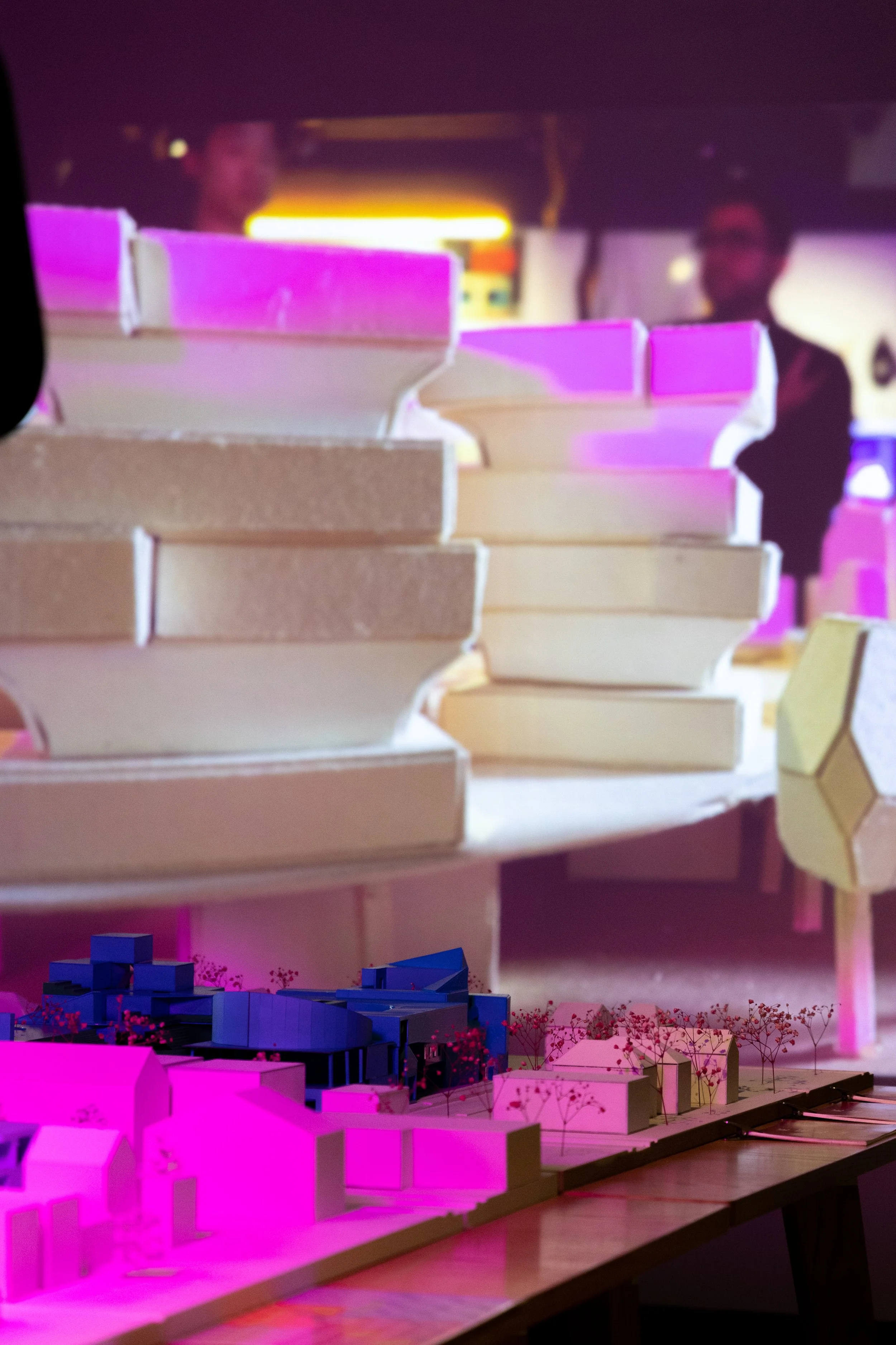 An architecture model with a purple light highlighting the work