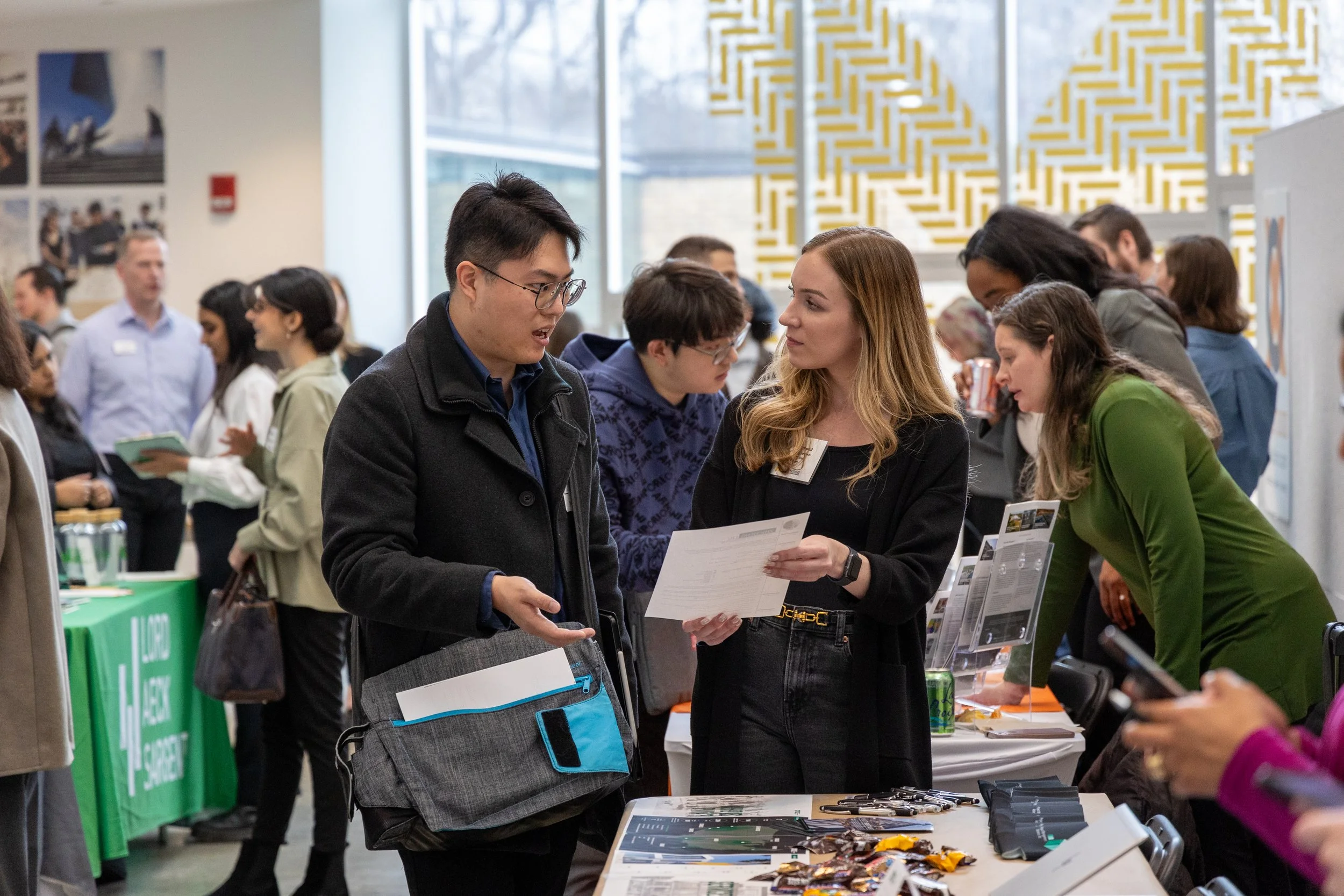 A man talks to a woman who is holding a piece of paper