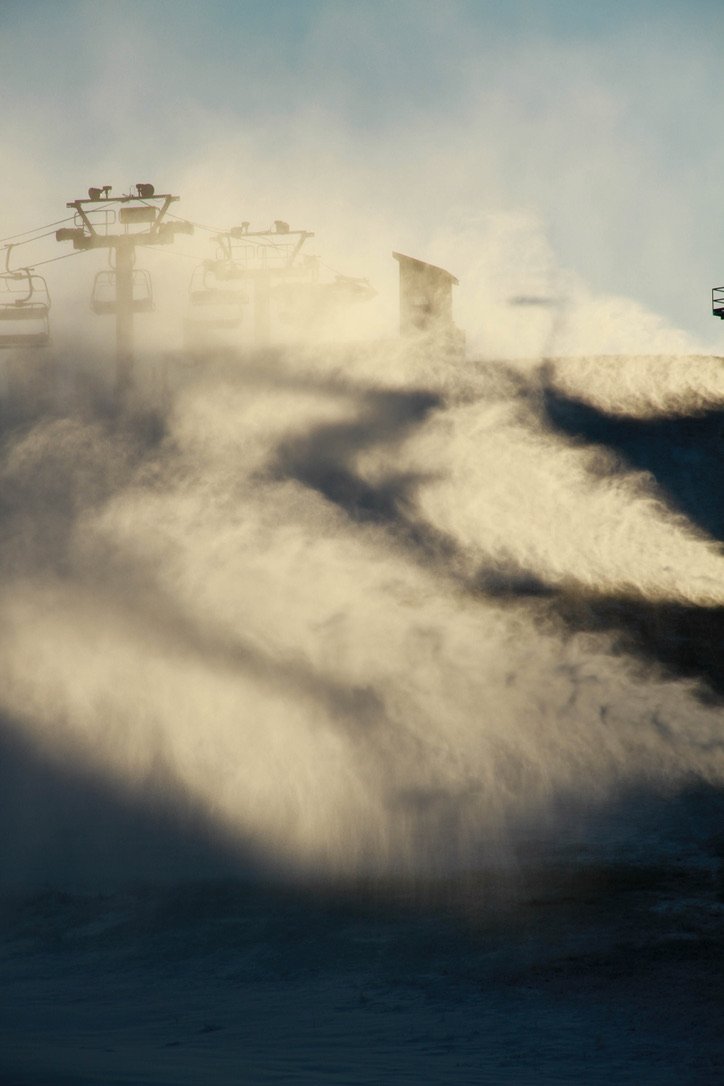 Snowmakers blow show into the light on an early morning