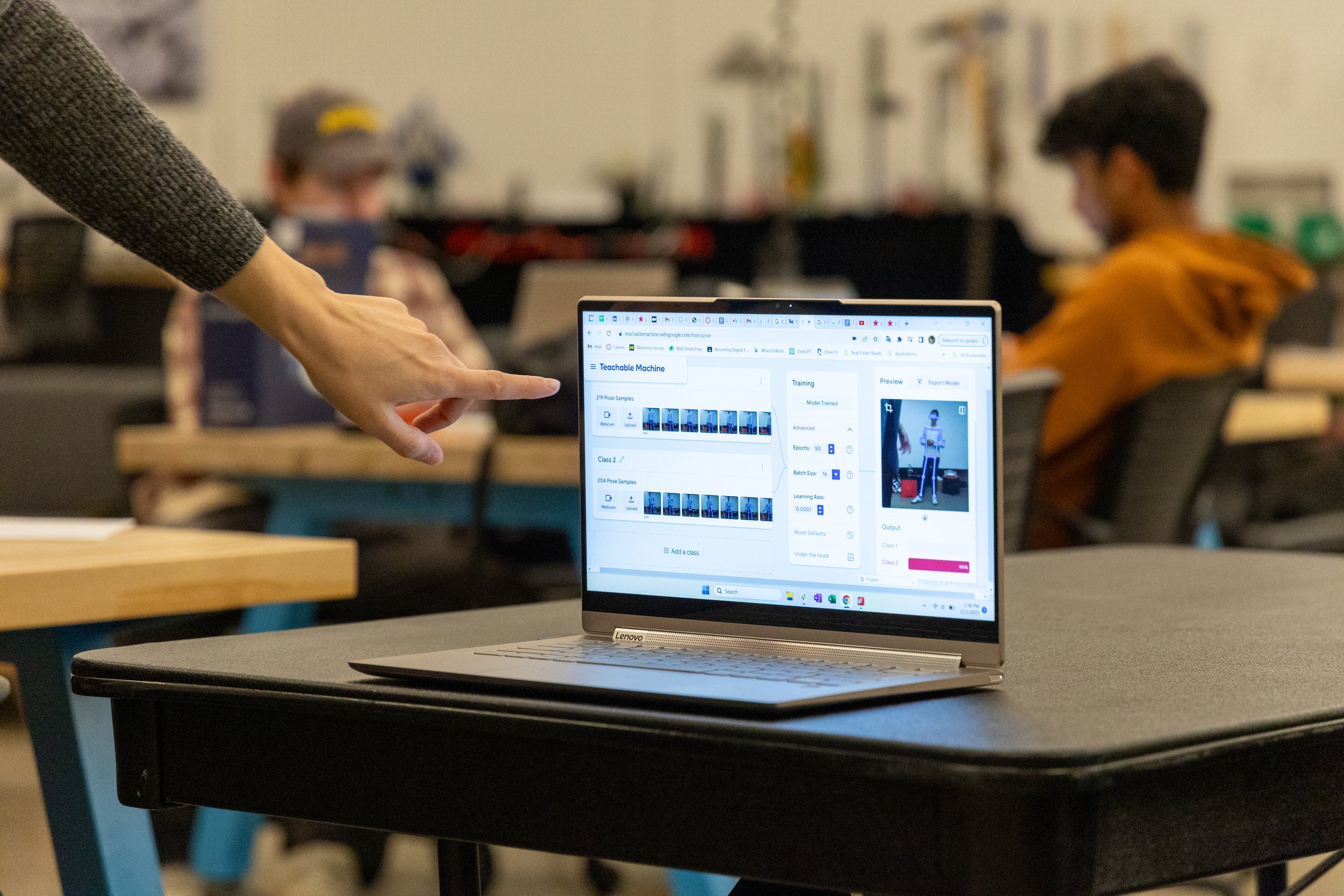 A hand points to a computer moniter with a program running on the screen