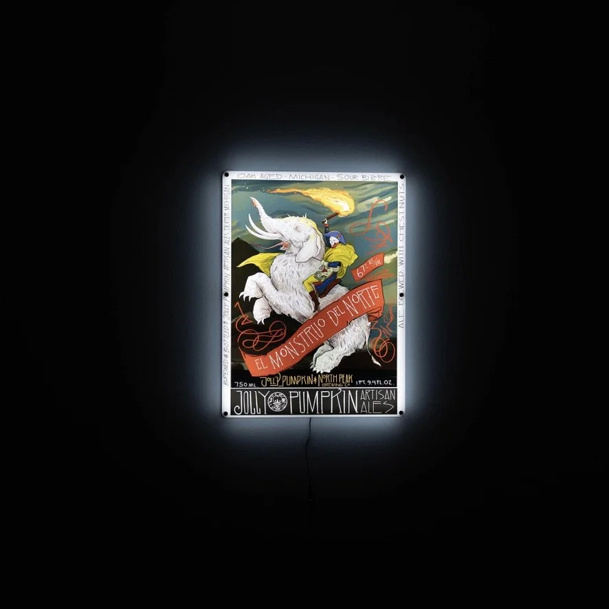 An illuminated LED sign with a man riding a white elephant