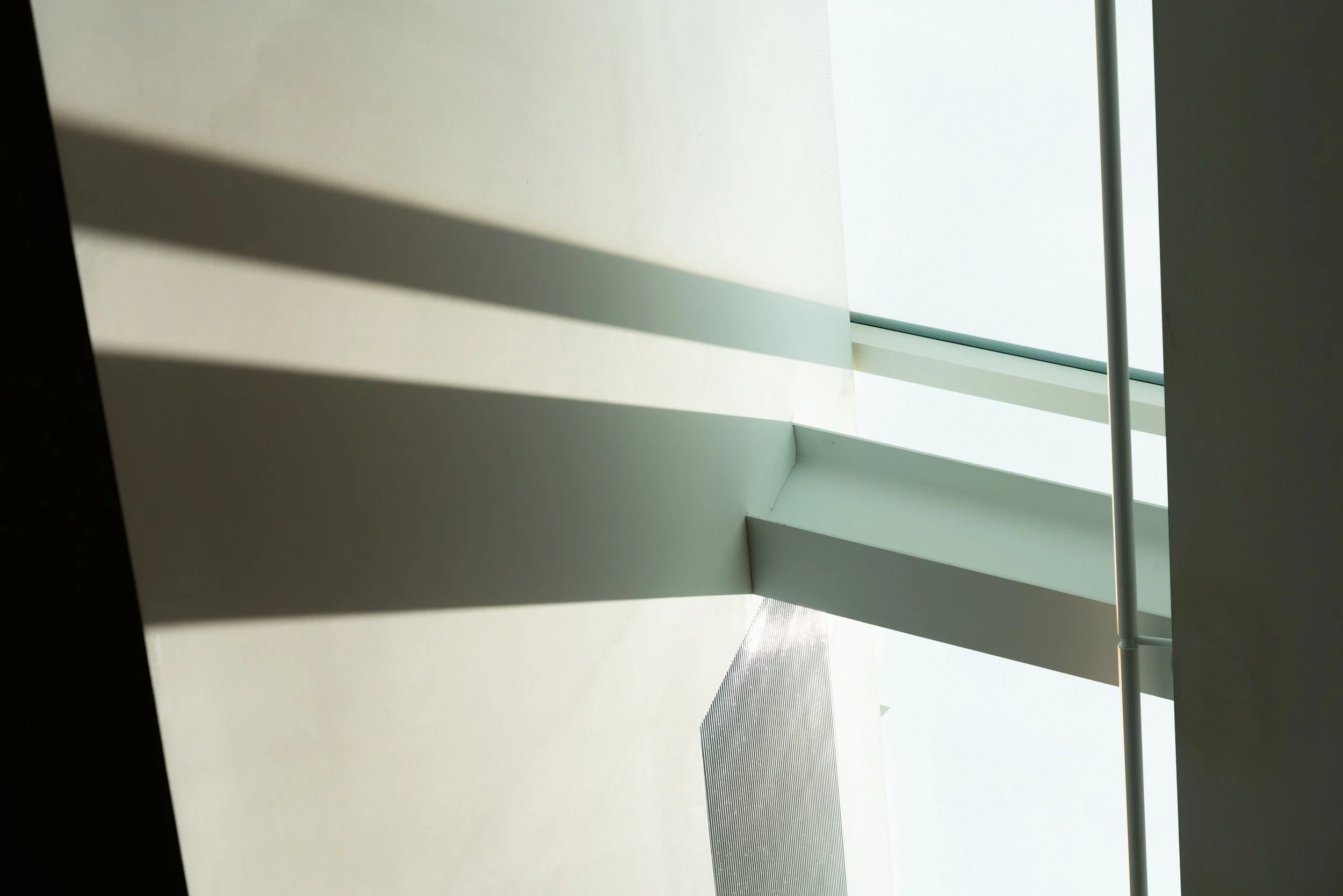 An abstract view of shadows and light coming into a skylight in a building