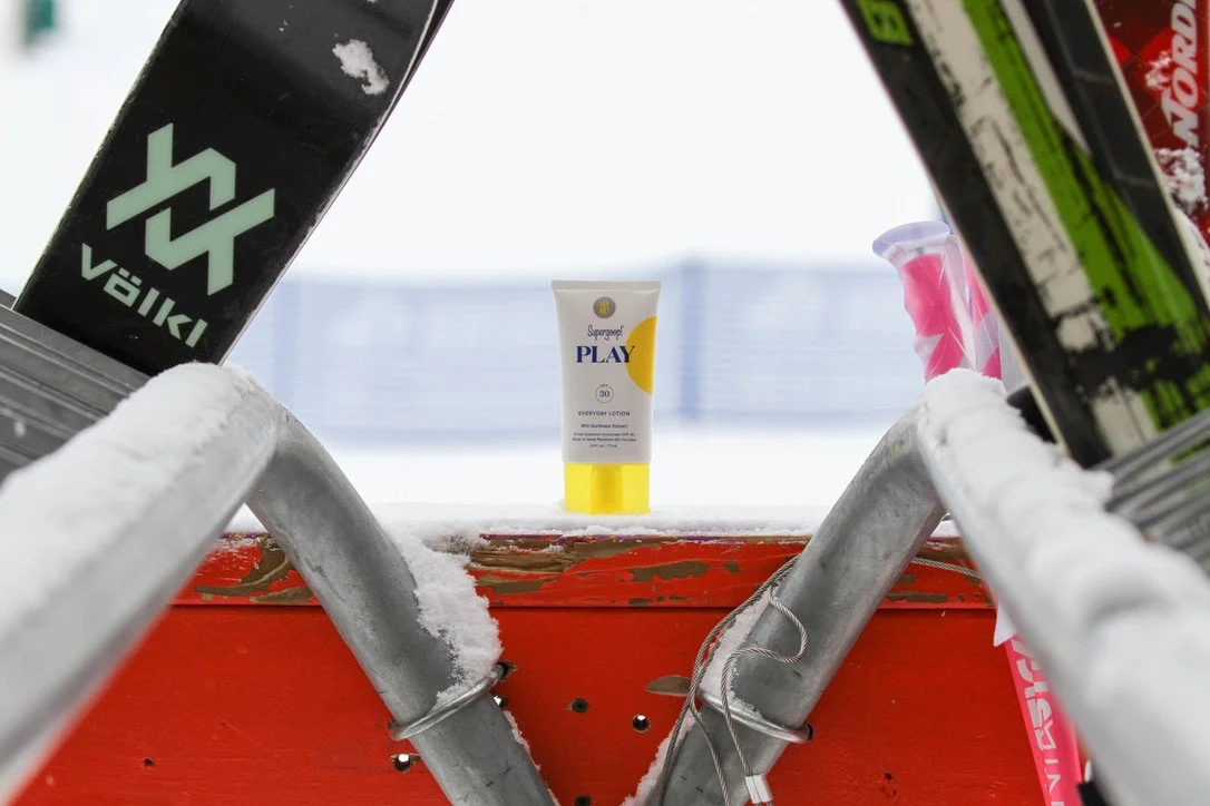 A sunscreen bottle sits at the end of a ski rack