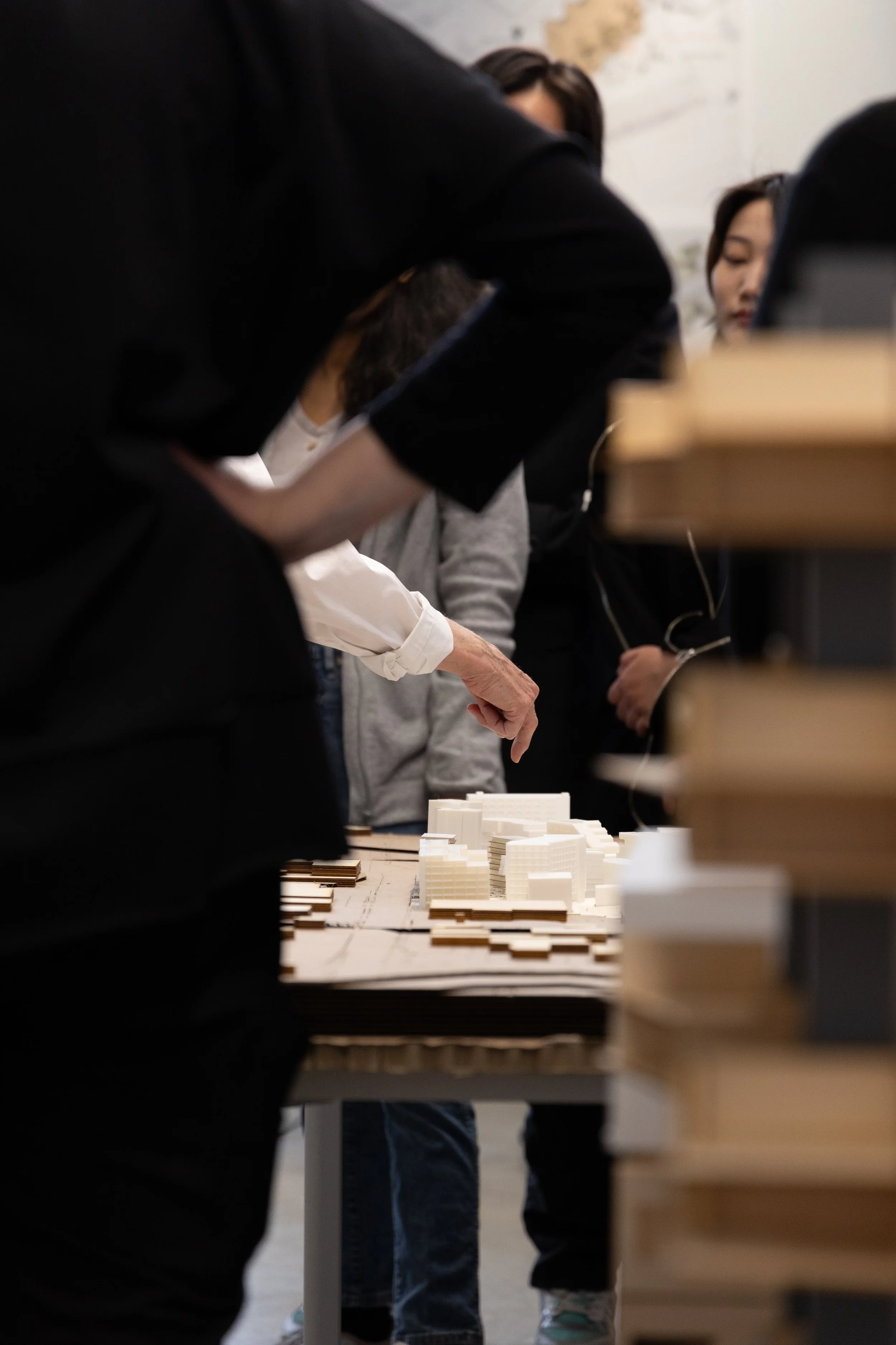 A hand points to a detail within an architecture model