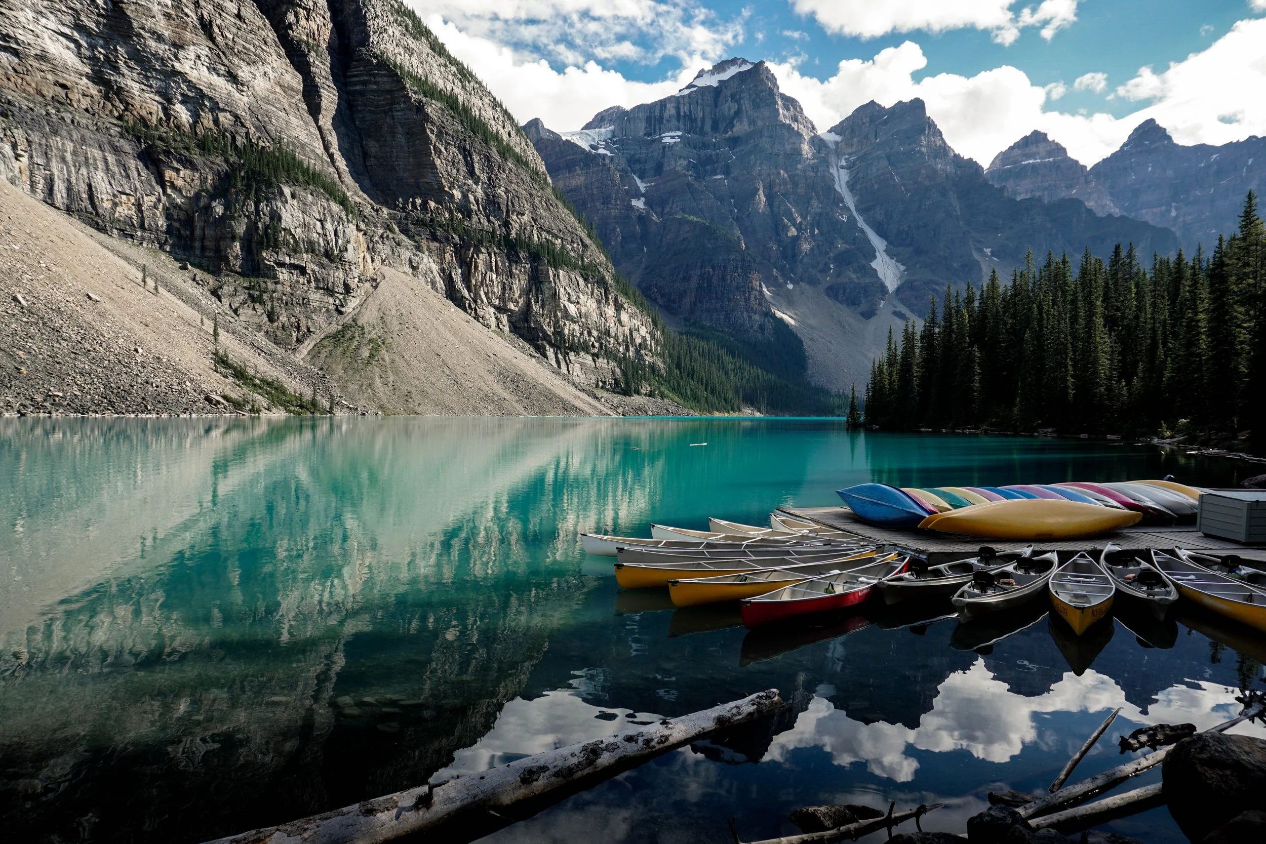 Morain Lake with canoes docked and moutain peaks in the background