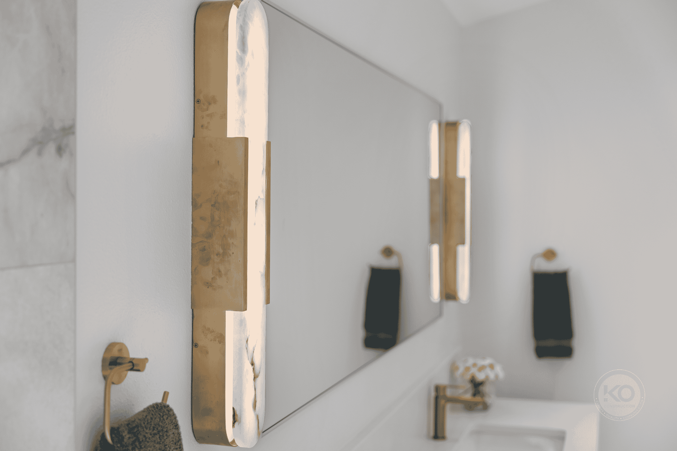 Custom vanity with illuminated mirror and brass fixtures in a Lake Tapps primary bathroom remodel.