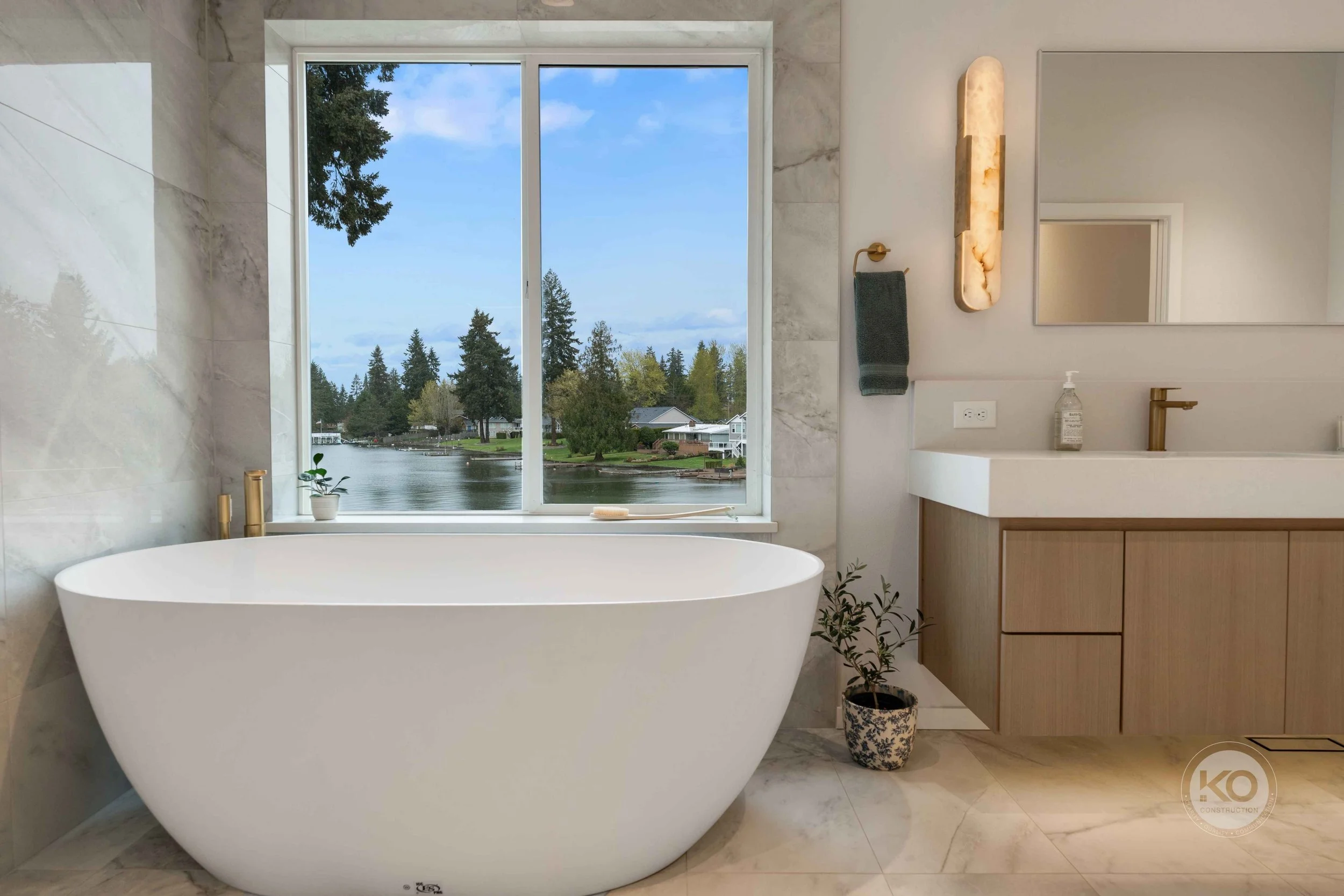 Luxury primary bathroom remodel in Lake Tapps, Washington featuring a freestanding tub, custom vanity, and waterfront views.