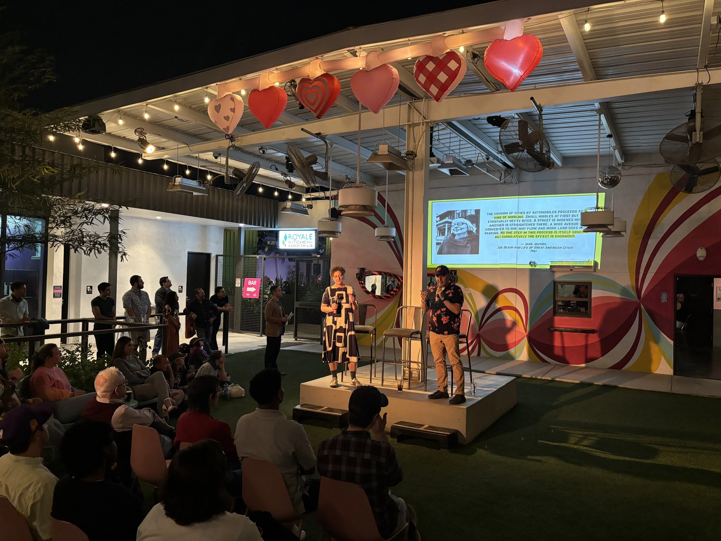 Sarah Goodyear and Doug Gordon speaking in front of a group of people