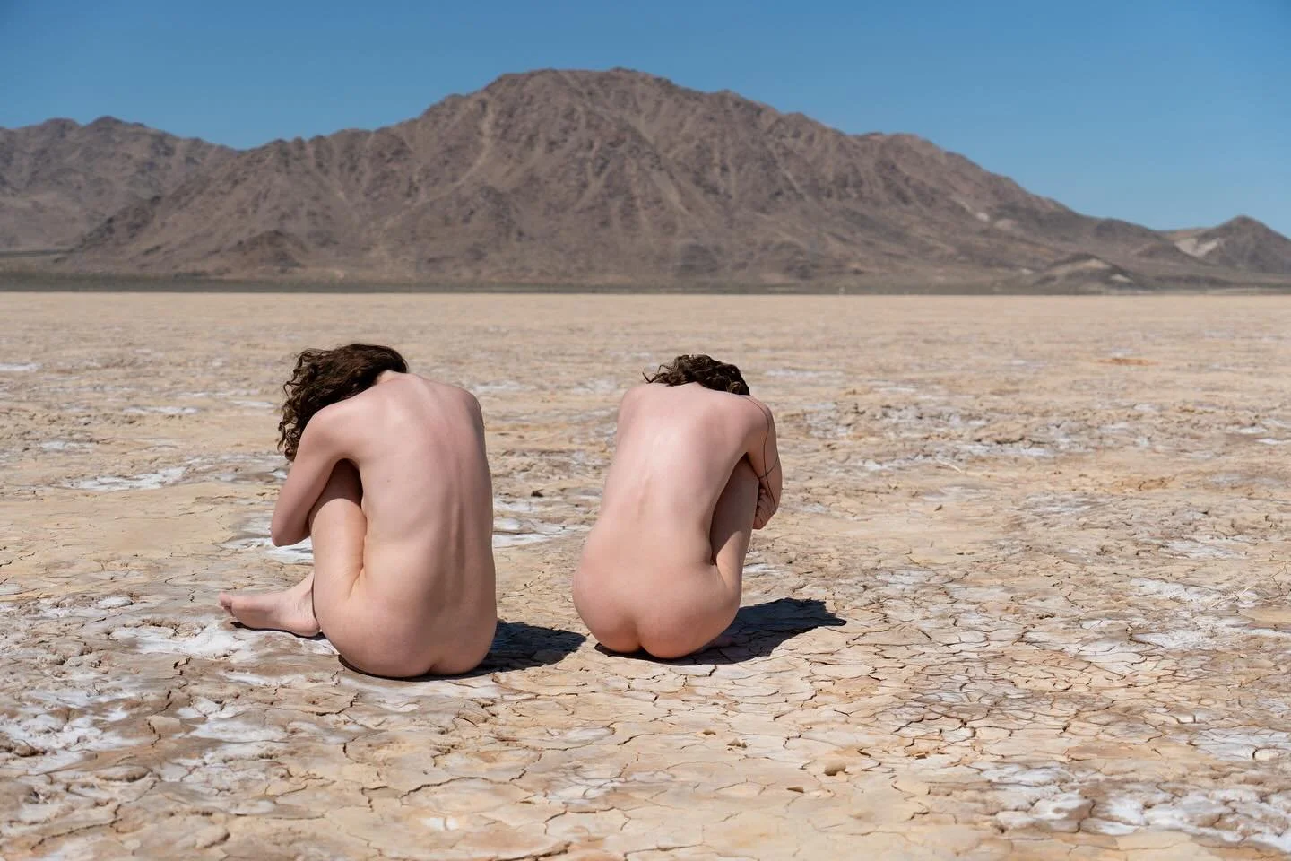 My body folds into the earth,
pressed soft against desert skin, still damp from rare rain&mdash;
one of two in a year,
and the last just passed.
I walk barefoot, slow,
each step sinking into cracked clay,
my soles remembering the shape of the land.
T