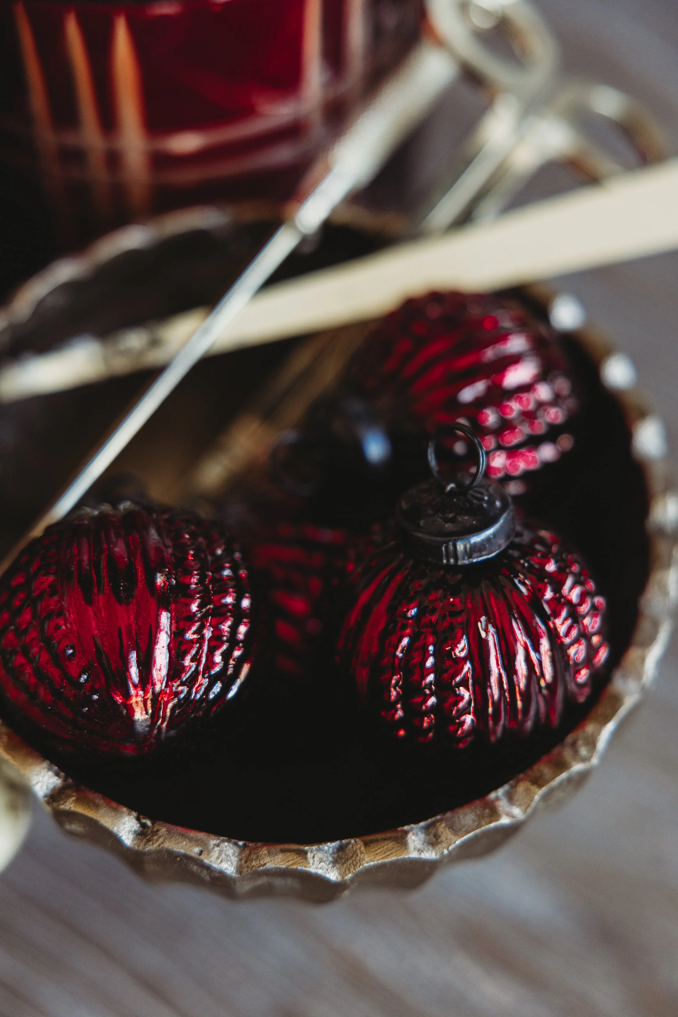 Close-up of red and black marbled hard candies in a silver foil candy cup.